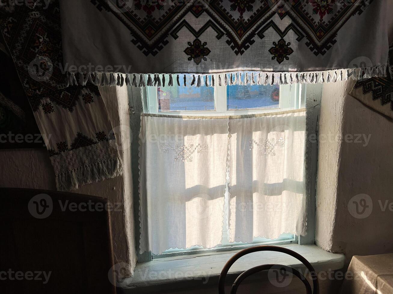 Vintage window with embroidered curtains in soft sunlight photo