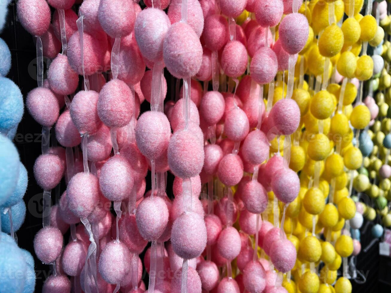 Colorful Decorative Pom Pom Strings in Pink, Yellow, and Blue on Display photo
