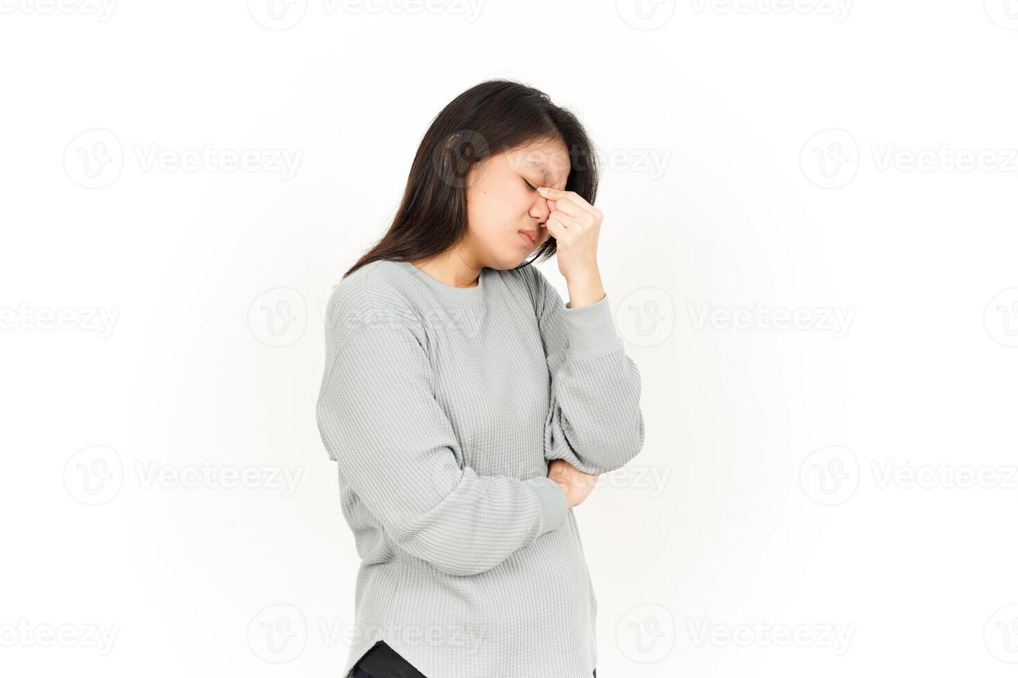 A woman is holding her head while looking down photo