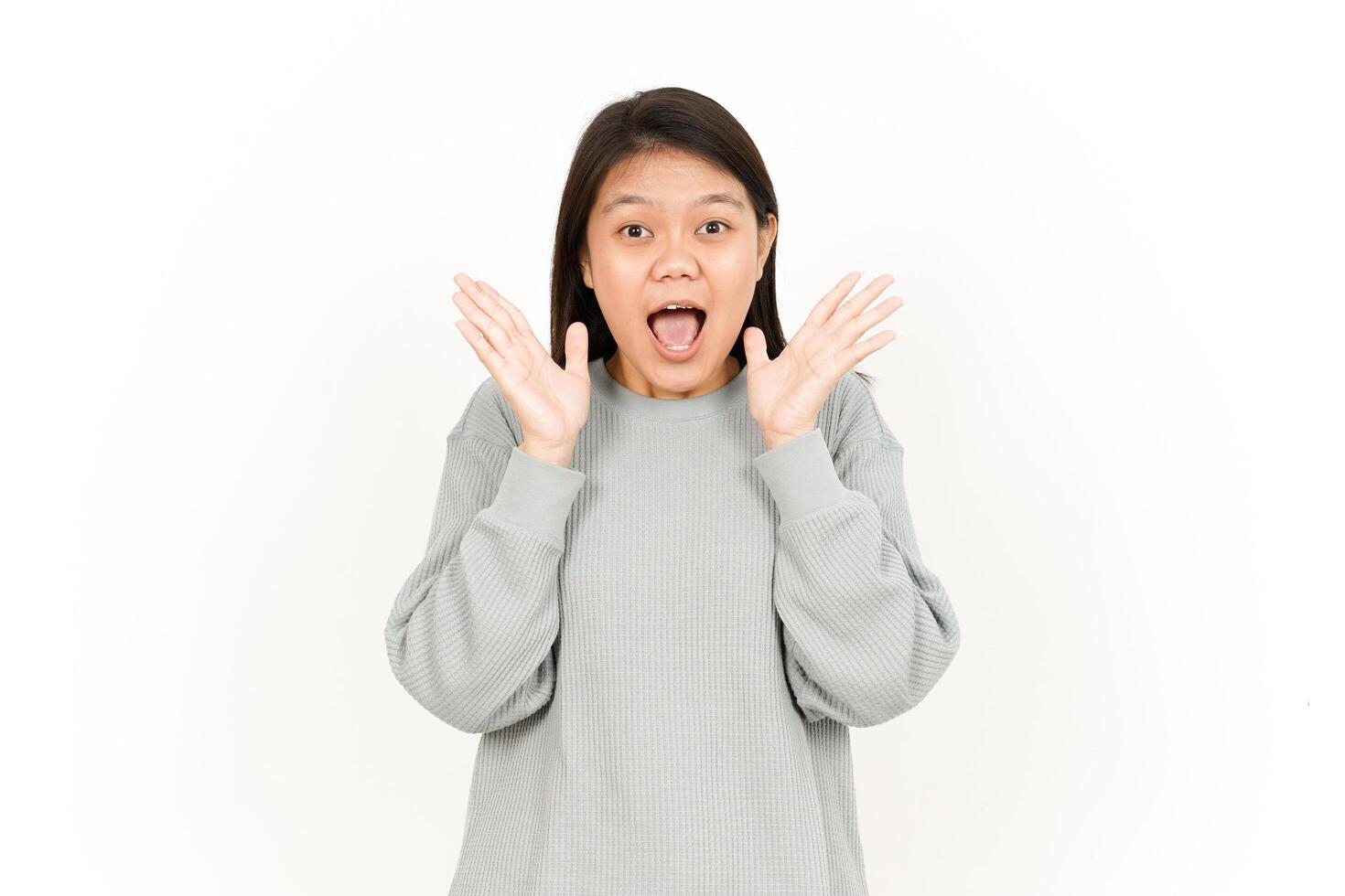 A woman is making a surprised face while standing in front of a white background photo