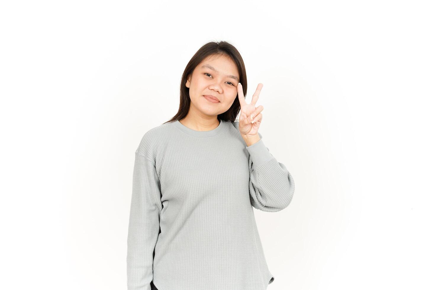 A woman in a gray sweatshirt making the peace sign photo