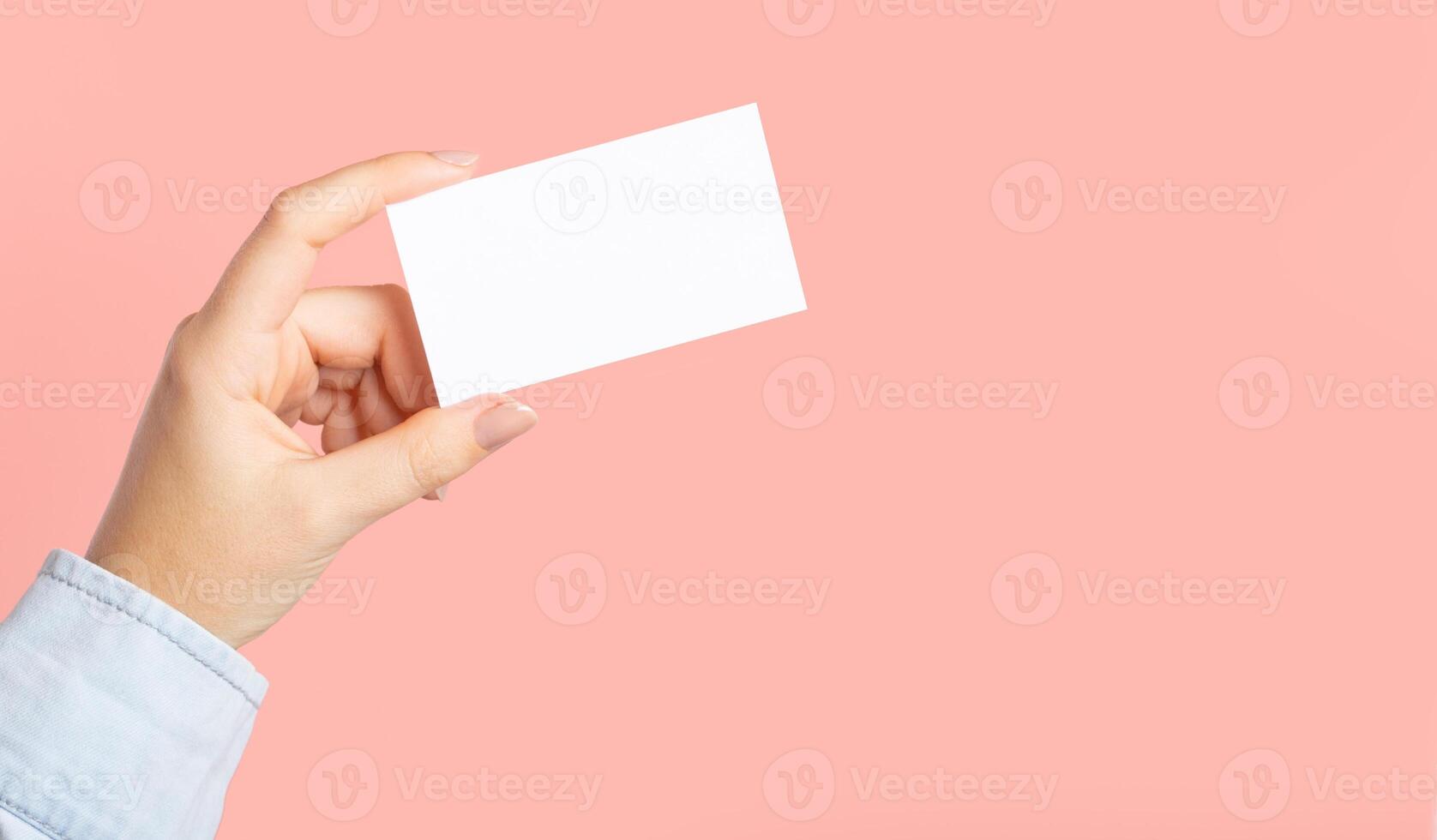 Female hands with cutaway, blank menu, discount card, business card on color pink beauty background. photo