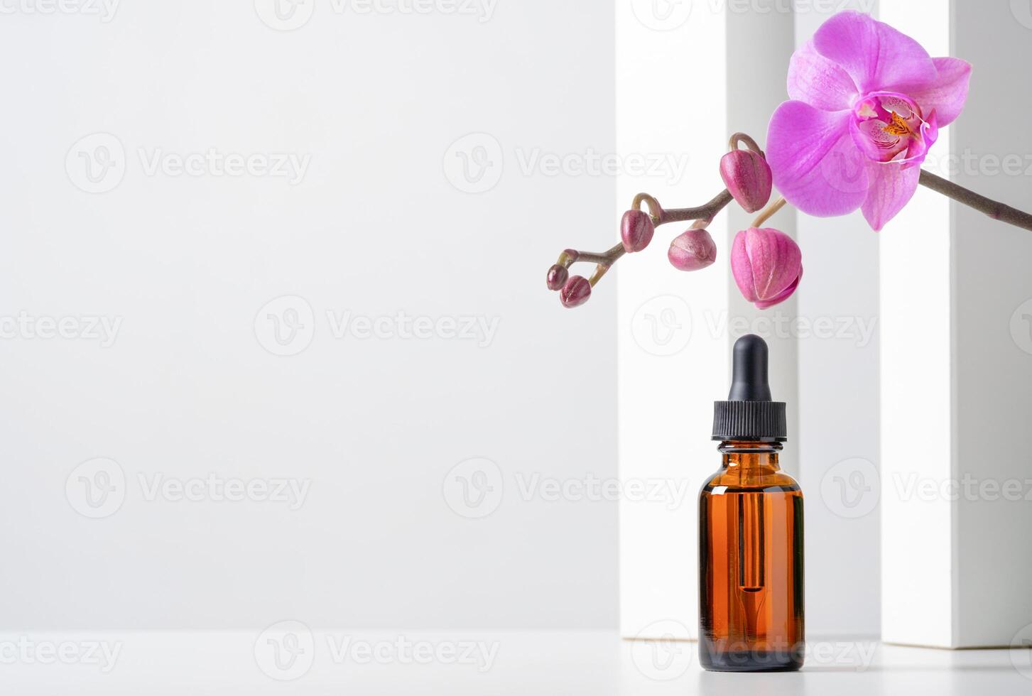 Mockup cosmetic face serum brown glass bottle with a pipette on stylish minimalist white background. photo