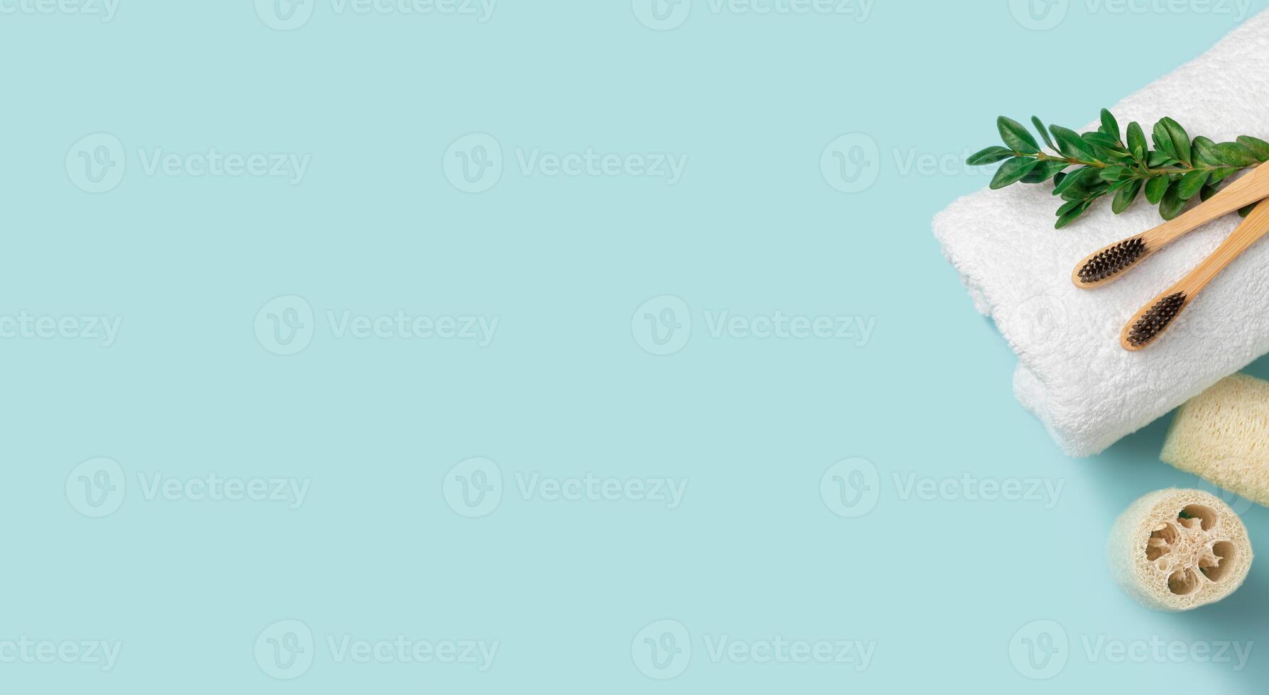 Bamboo toothbrushes on a white towel are on a blue background. Loofah. Banner with copy space photo