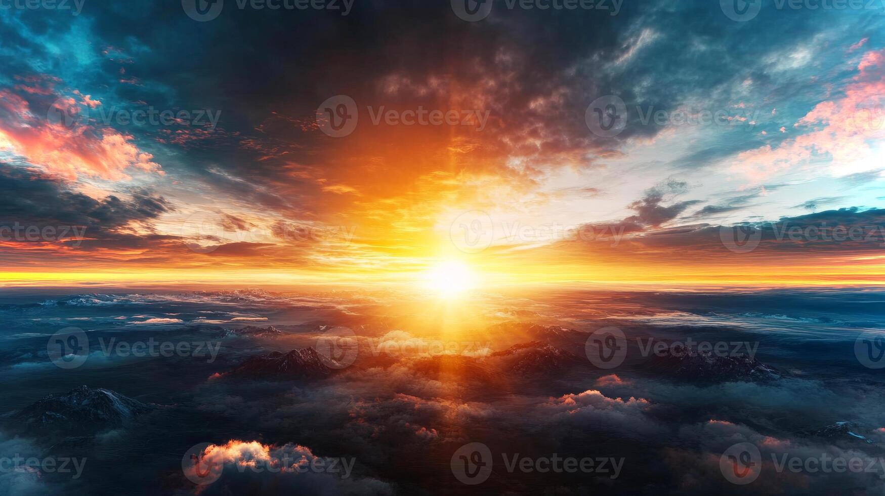 A breathtaking sunrise illuminates the sky, casting golden light across the clouds and mountains below. photo