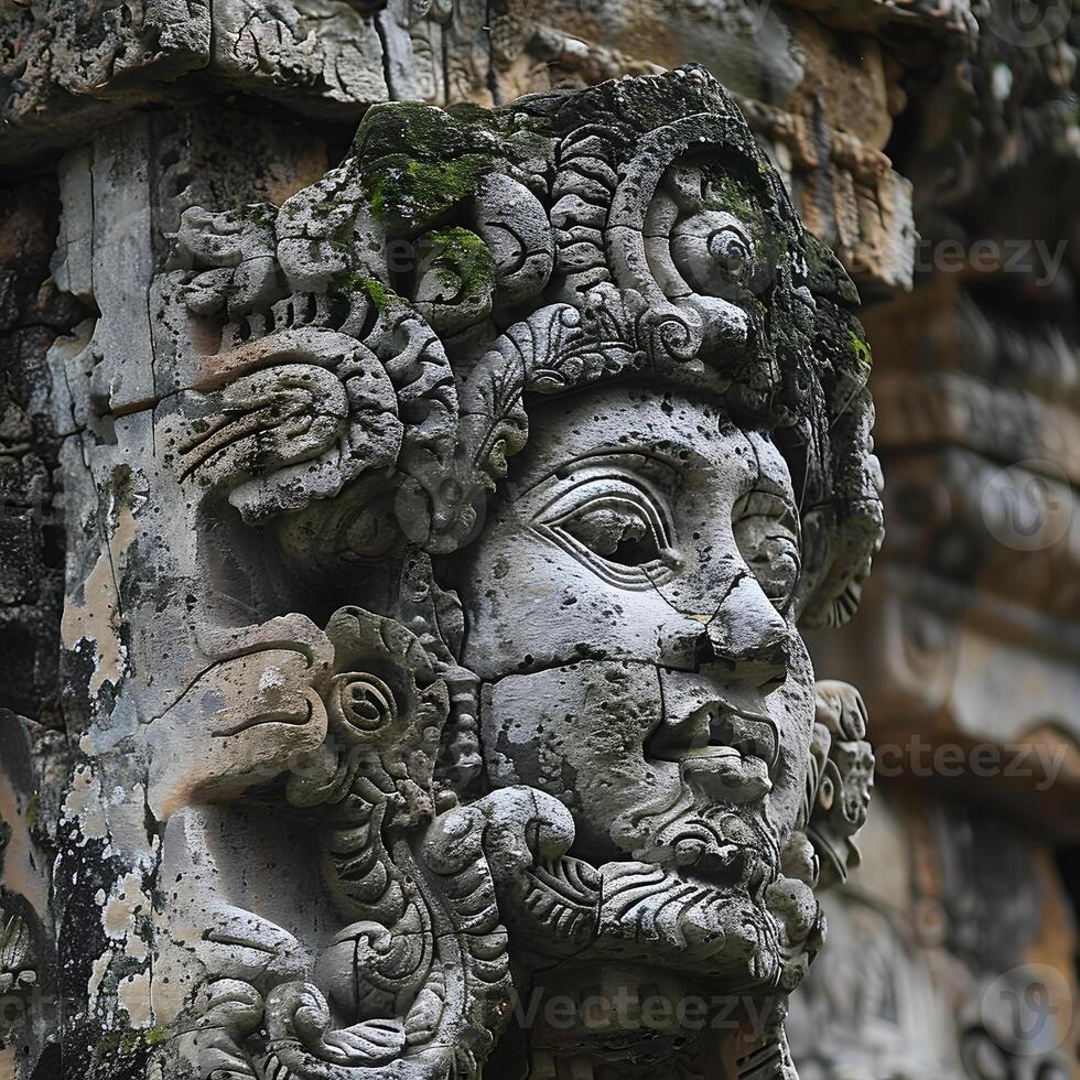 An ancient sculpture of a mans face carved in a stone column photo