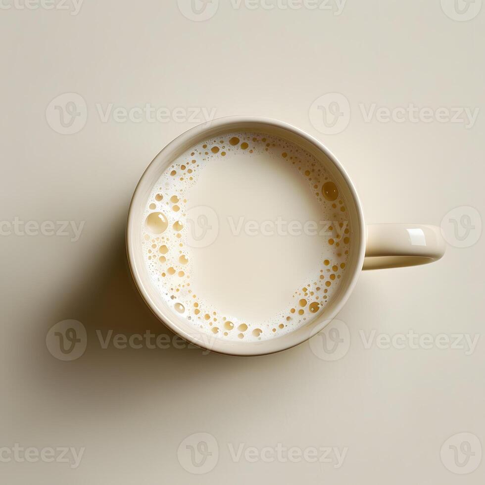 A cup of milk rests on a porcelain dishware on the table photo