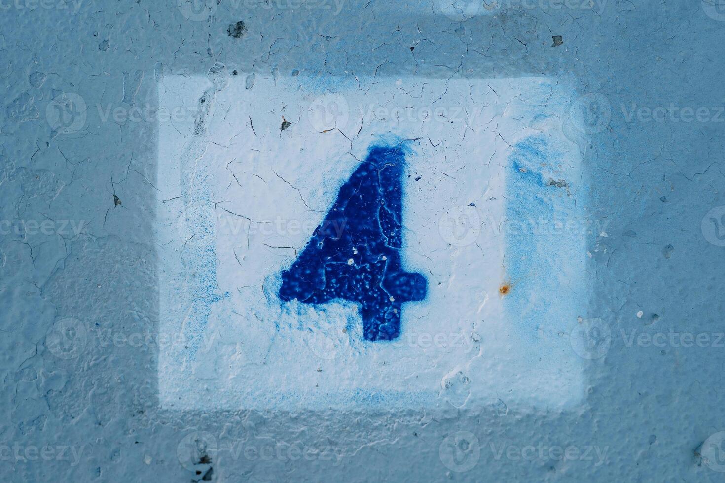 Number four with blurred edges drawn on a blue wall in a white rectangle photo
