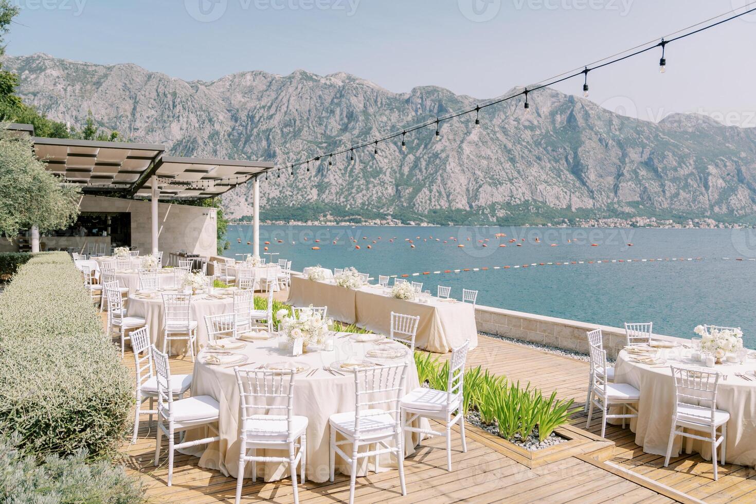 Festive tables on wooden floors in the courtyard of the villa overlooking the sea photo