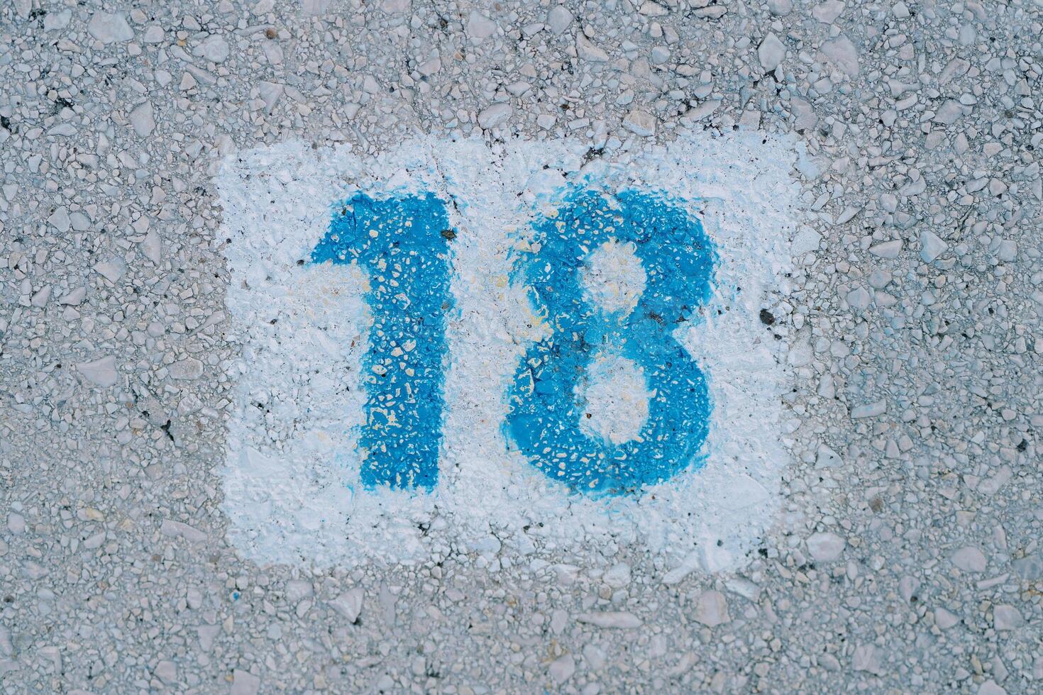 Number 18 is drawn on the pavement in a white rectangle photo