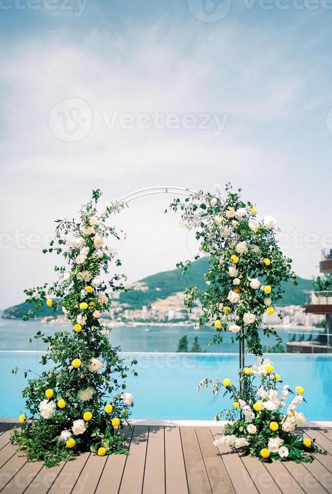Colorful wedding arch stands on the shore of the pool photo