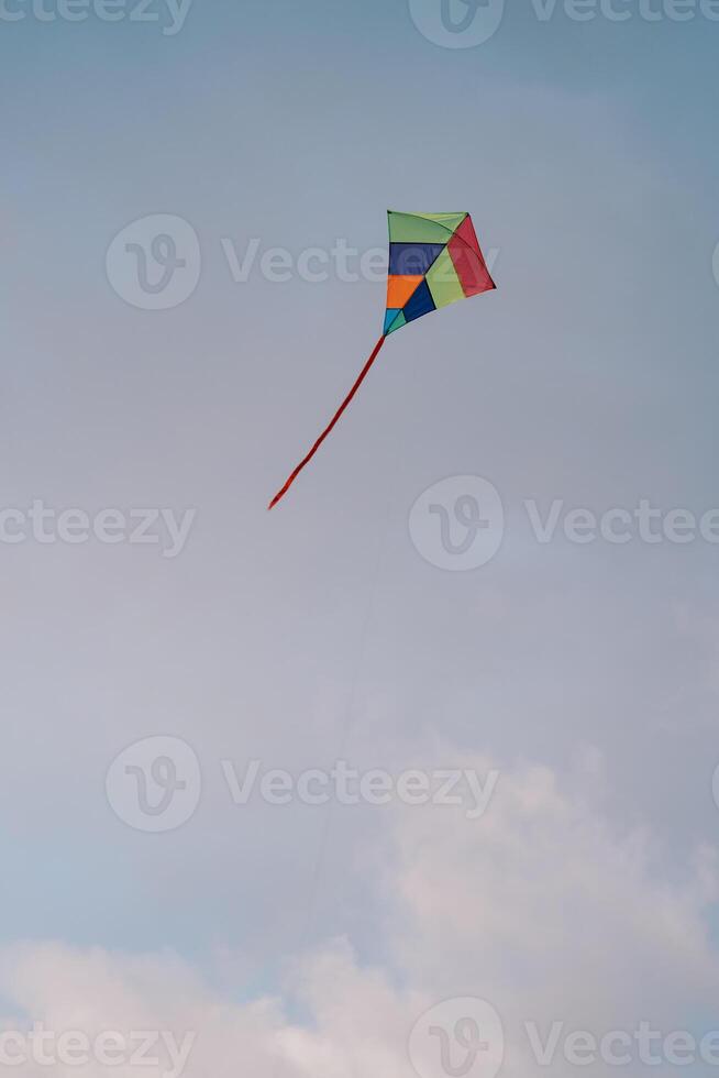 Rainbow kite soars in the cloudy sky photo