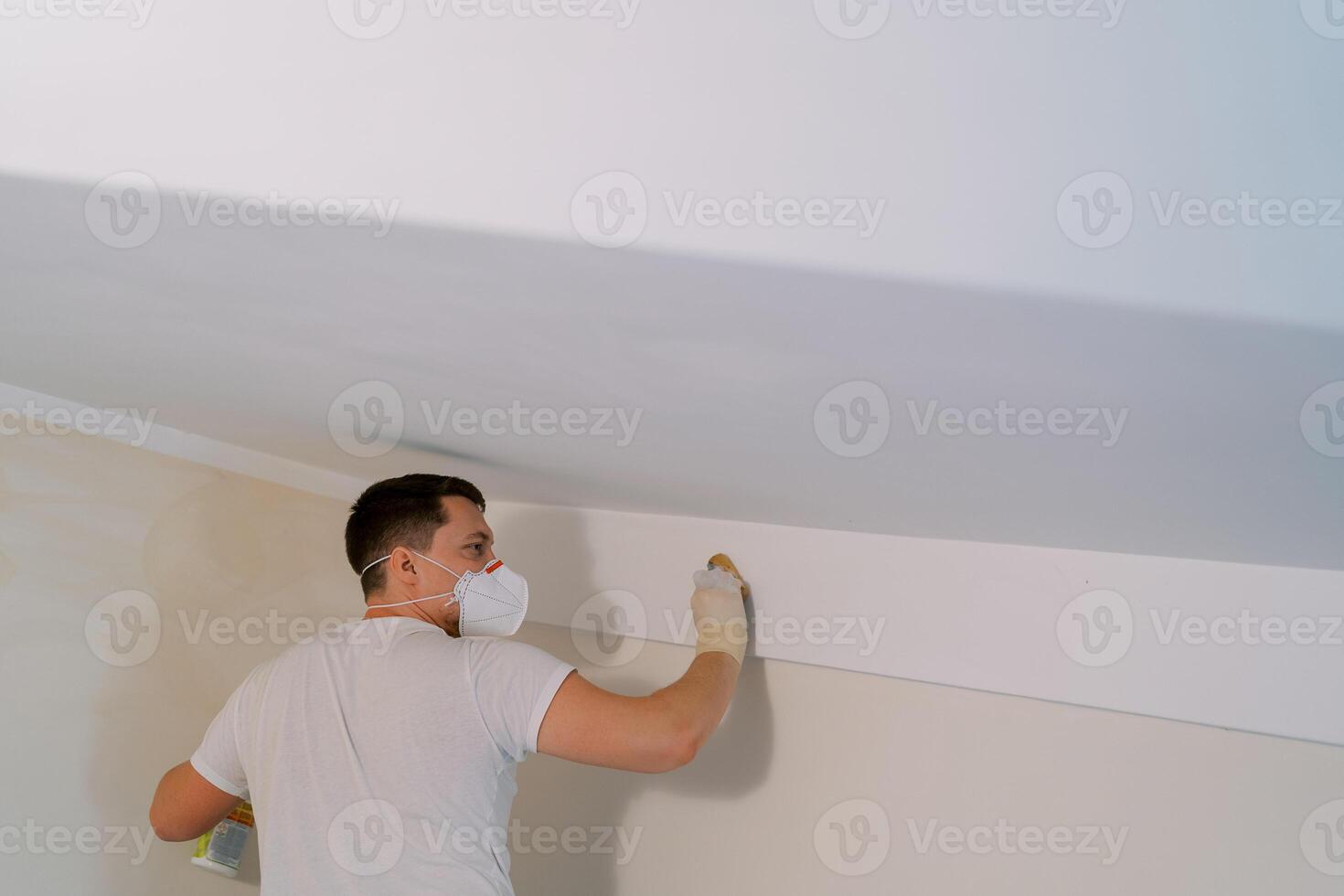 Disinfector washes the walls under the ceiling with a sponge photo