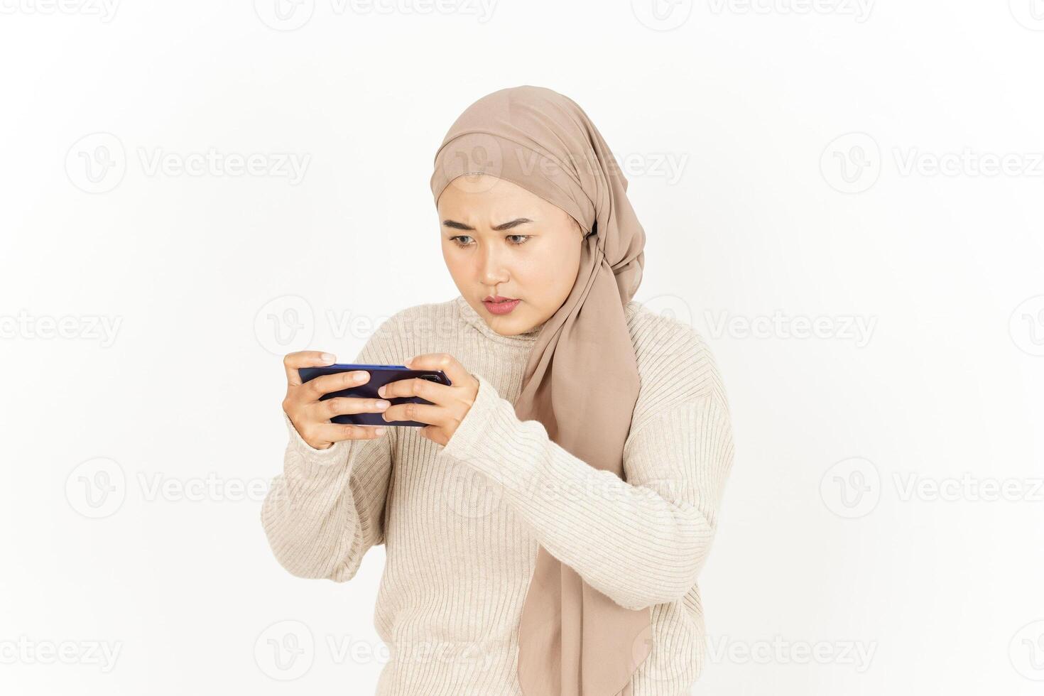 A woman wearing a hijab holding a cell phone photo