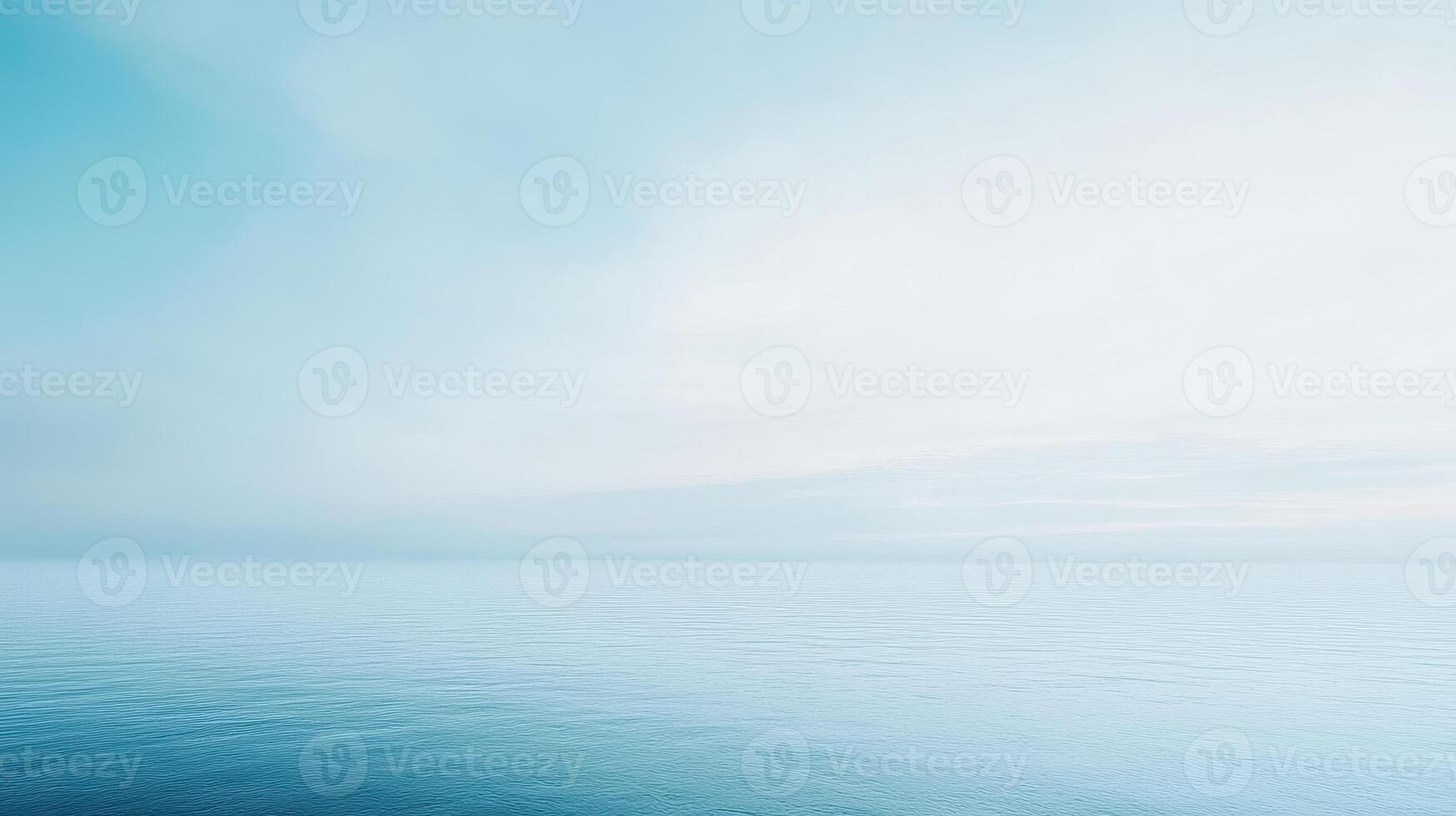 A serene view of a calm ocean under a soft blue sky photo