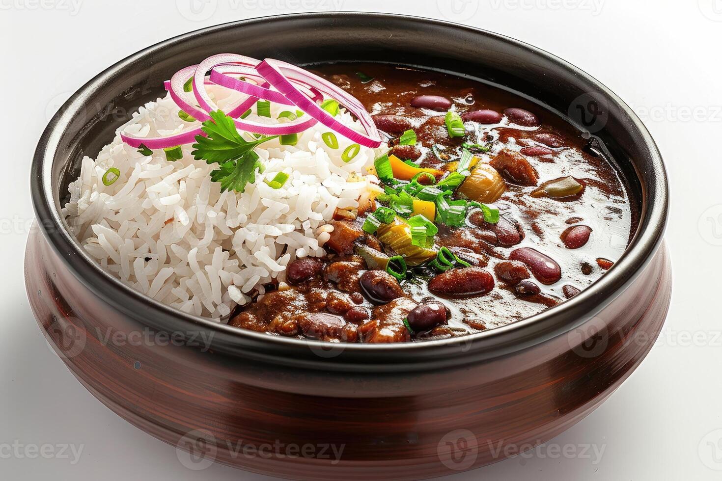 A bowl of rice served with a rich bean stew, garnished with onions and herbs photo