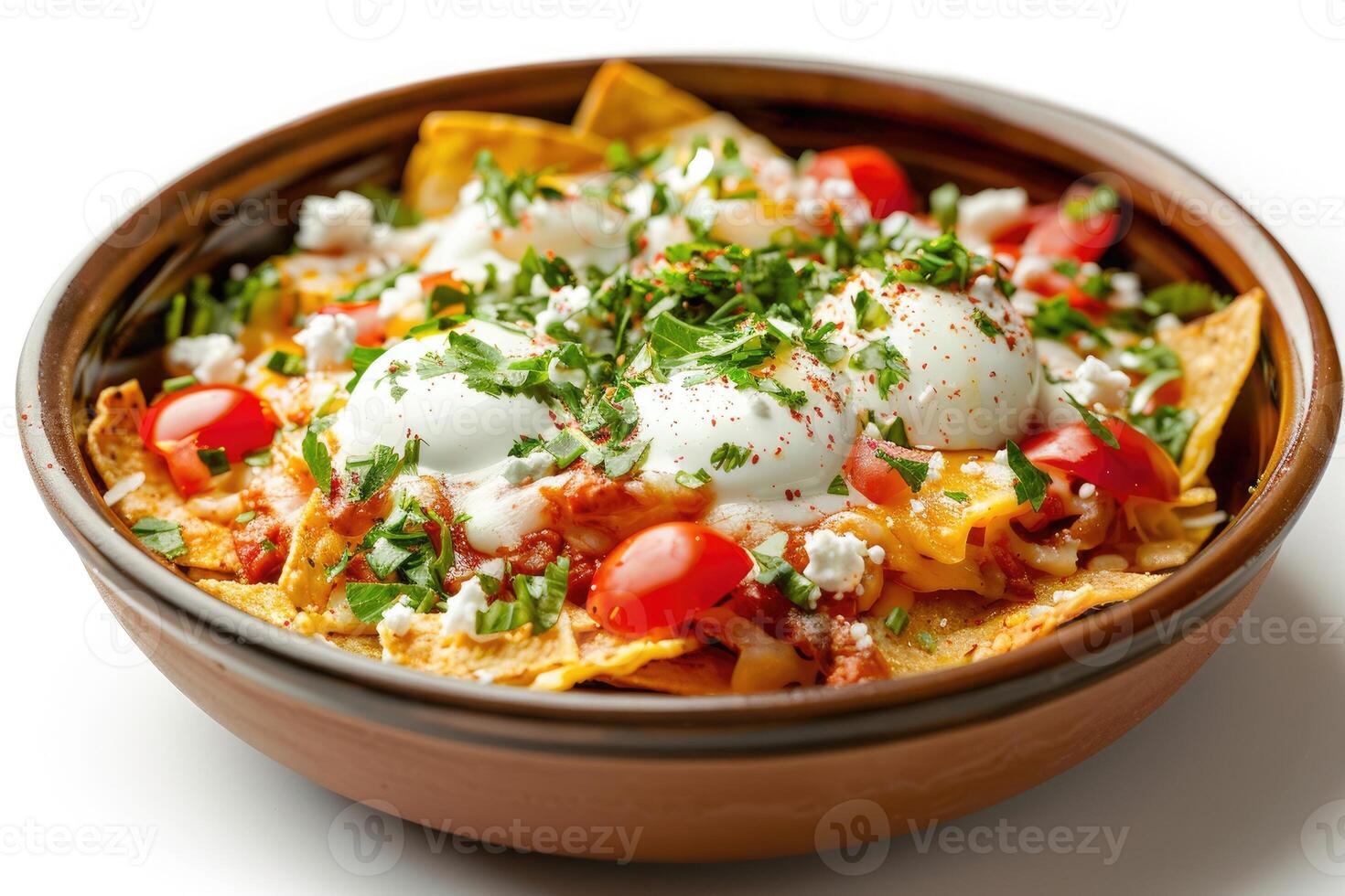 A delicious dish of nachos topped with eggs, tomatoes, and herbs photo