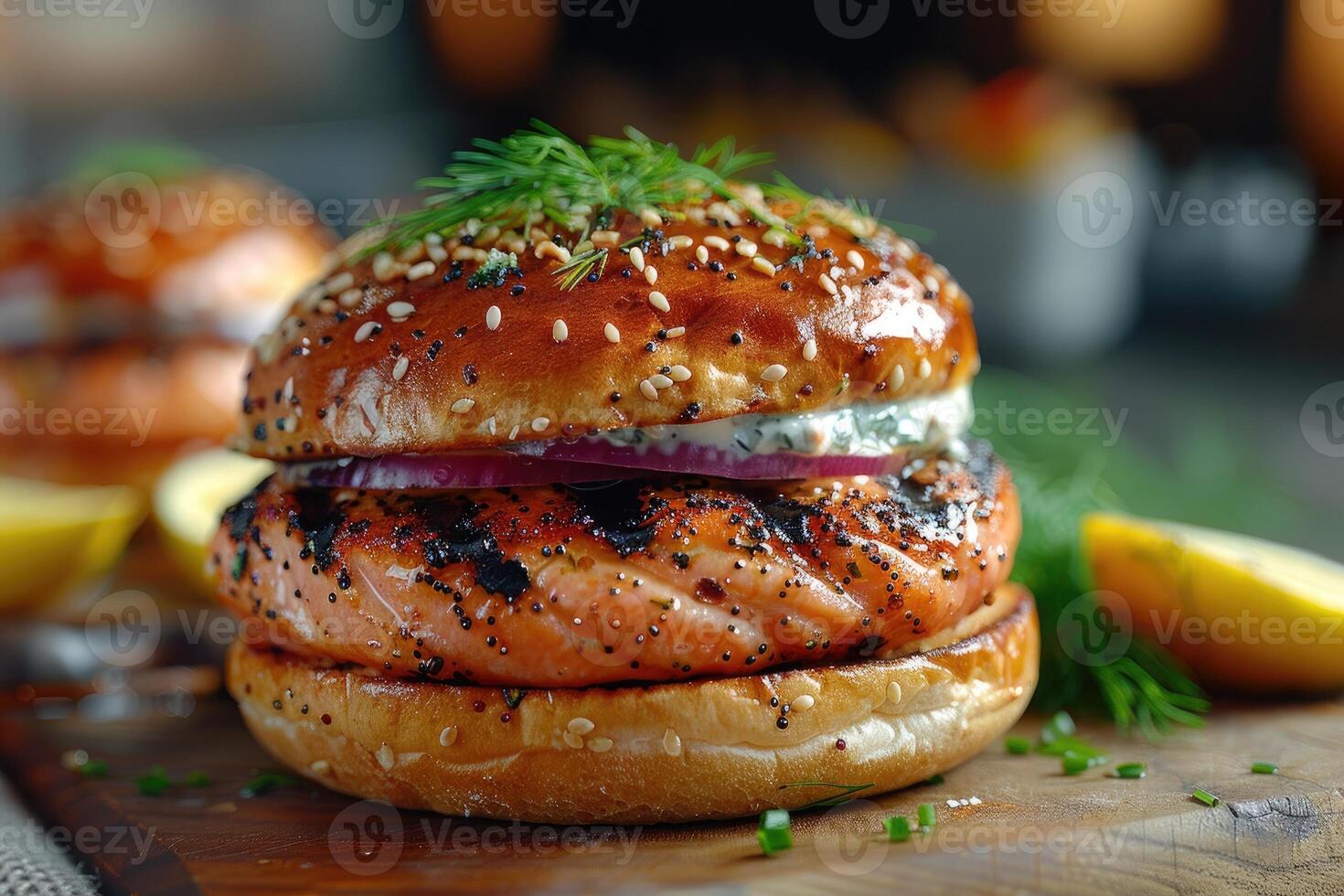A delicious salmon burger garnished with herbs, served with lemon wedges photo