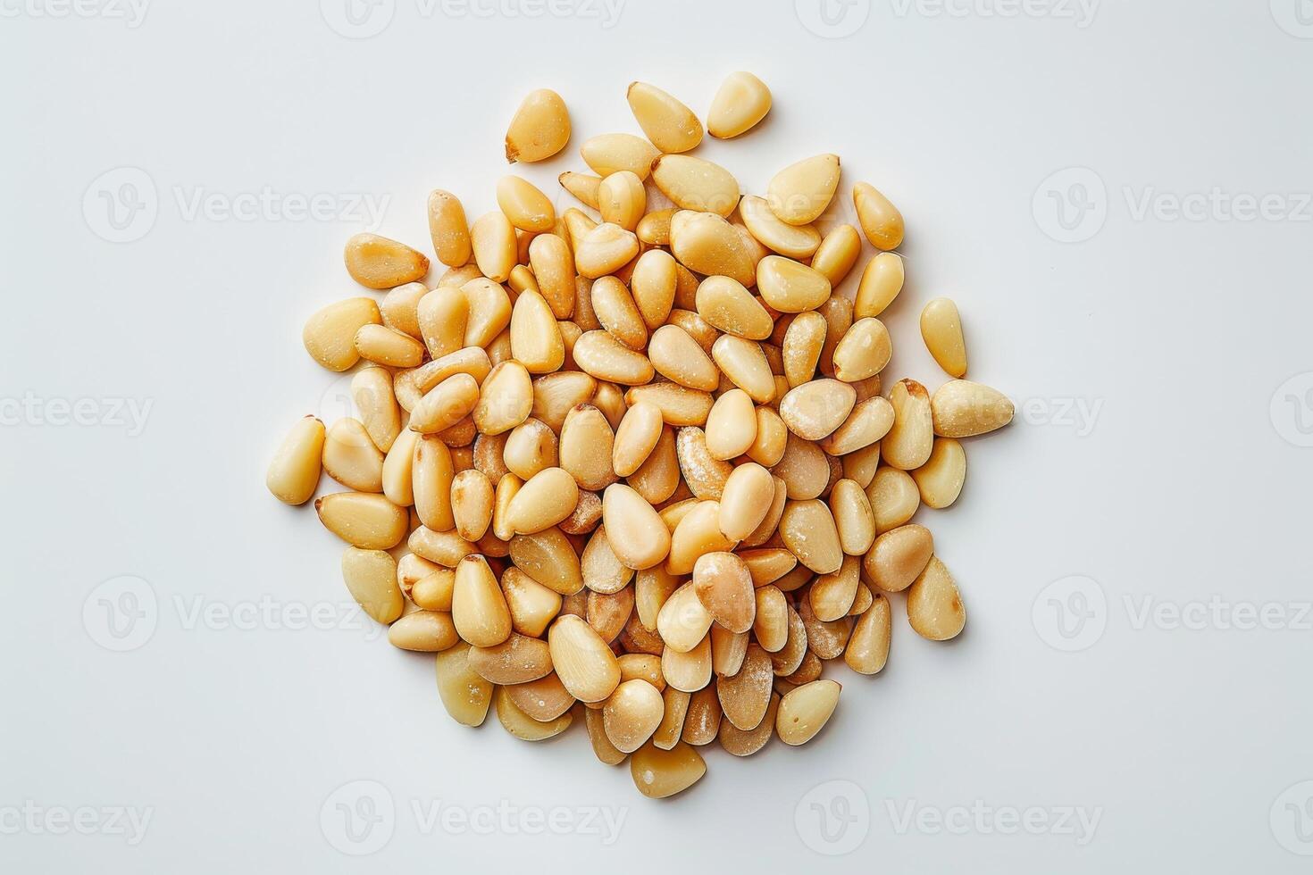 A pile of light brown pine nuts on a white background photo