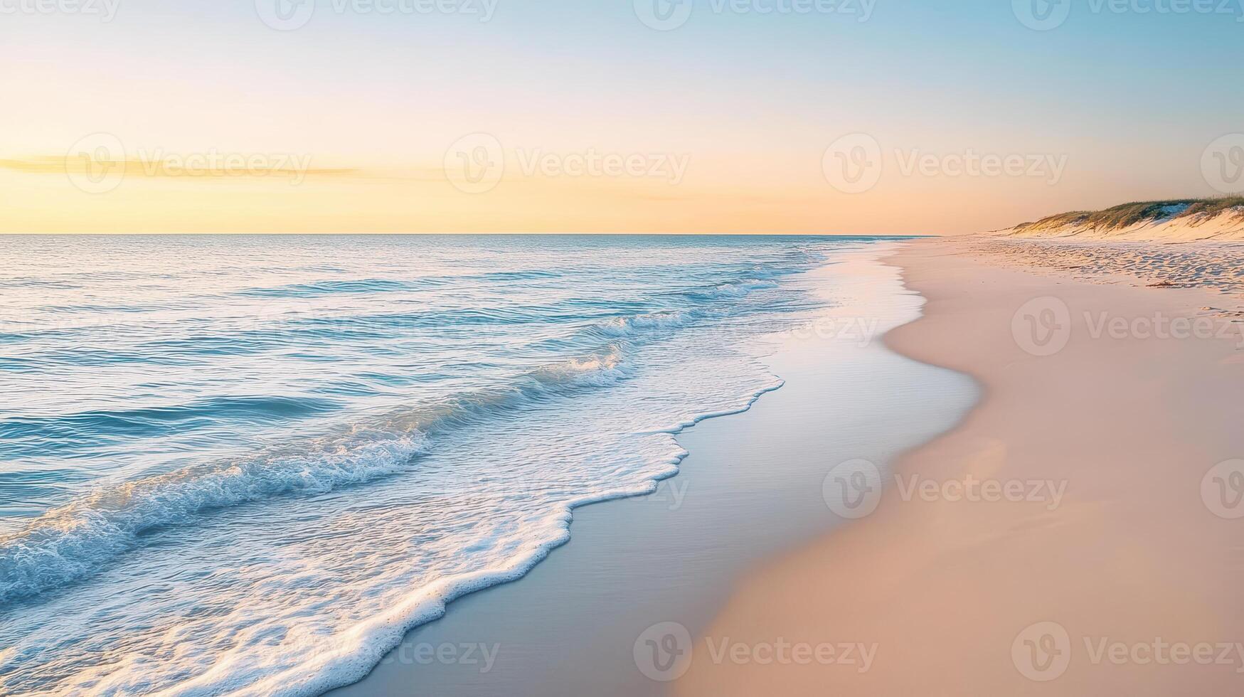 A serene beach at sunrise with gentle waves lapping against the shore photo
