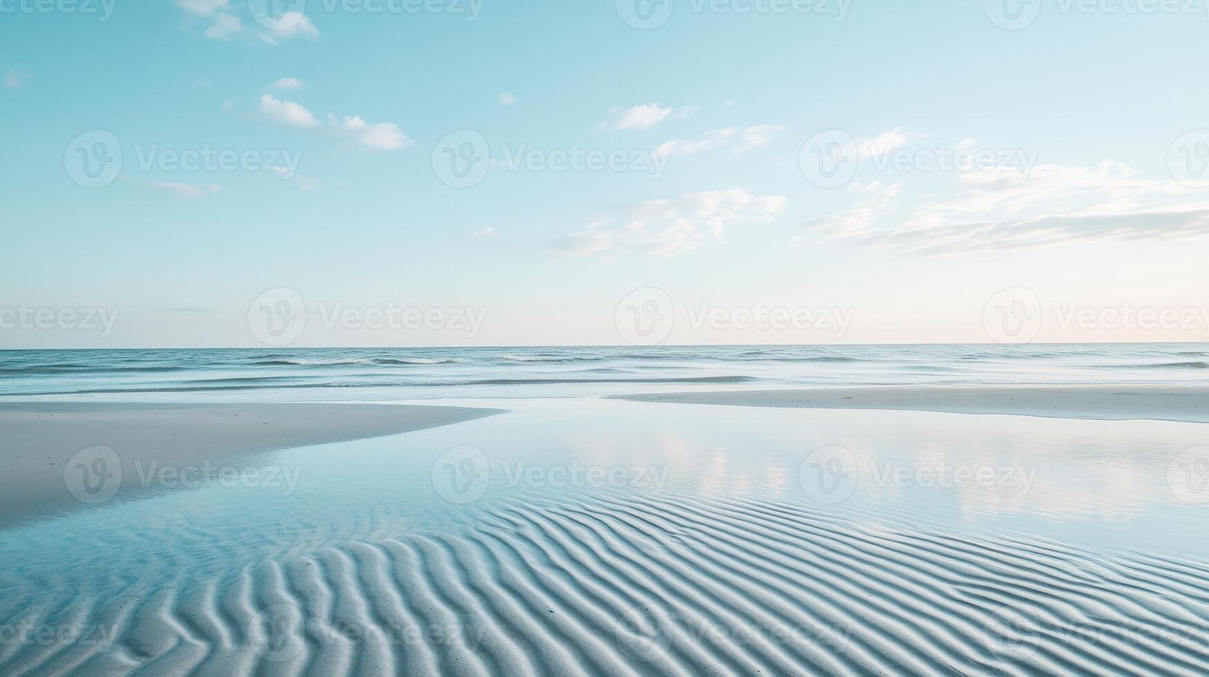 A serene beach scene with gentle waves and a clear sky reflecting on the sand photo