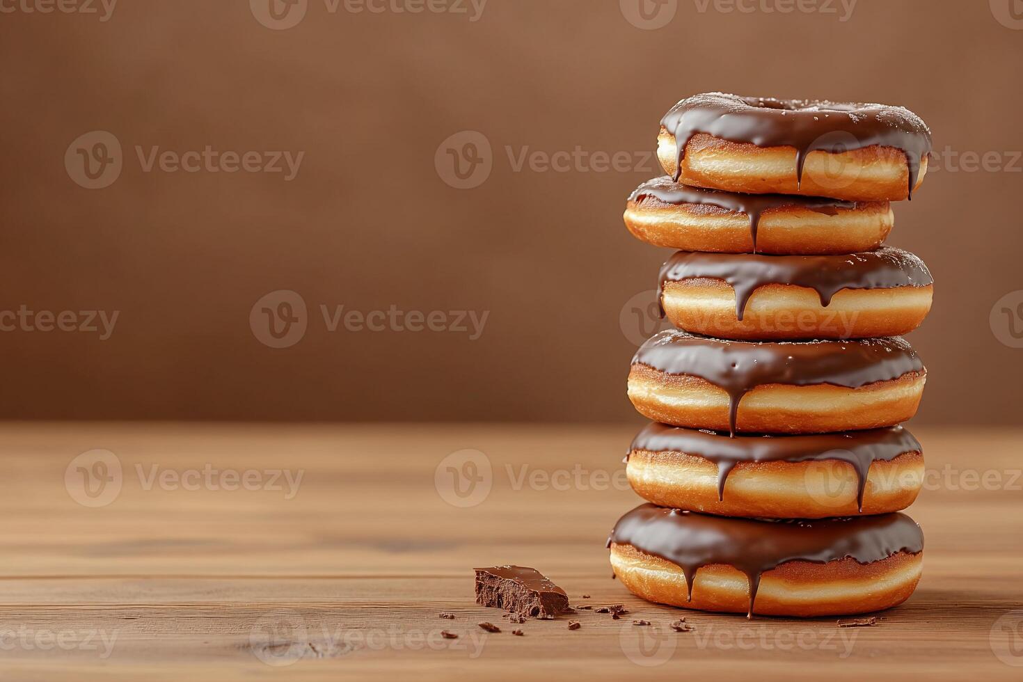 Stack of chocolate glazed donuts on a wooden table photo