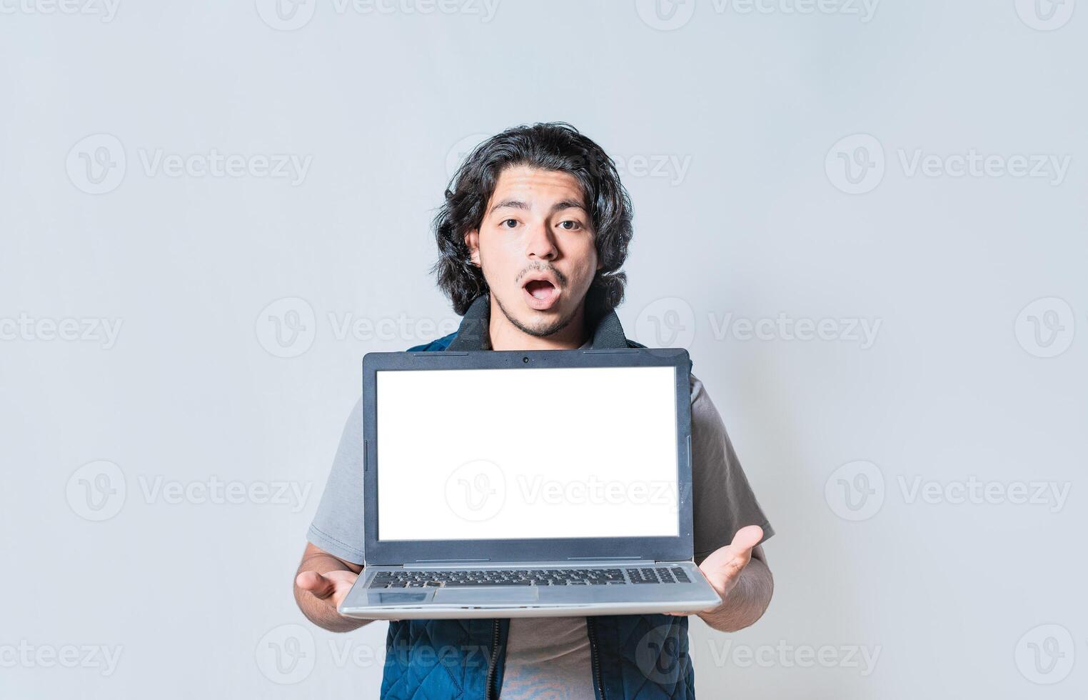 Amazed young man showing laptop screen isolated. Surprised guy showing laptop screen photo