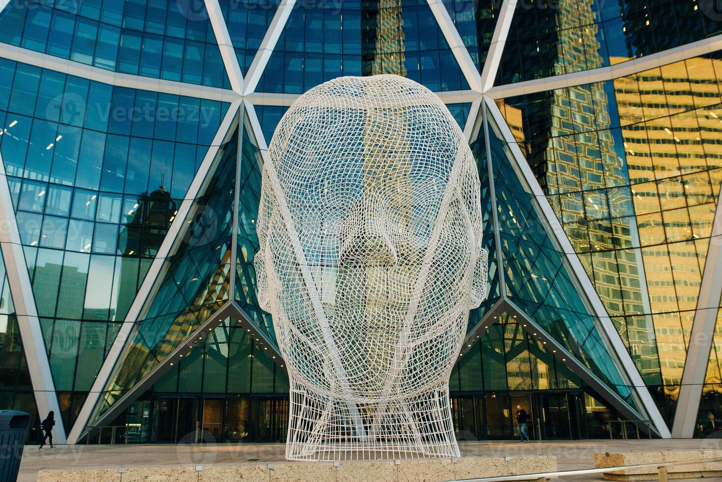 Calgary, Alberta, Canada - August 2019 Wonderland sculpture by famous artist Jaume Plensa in front of The Bow tower. photo
