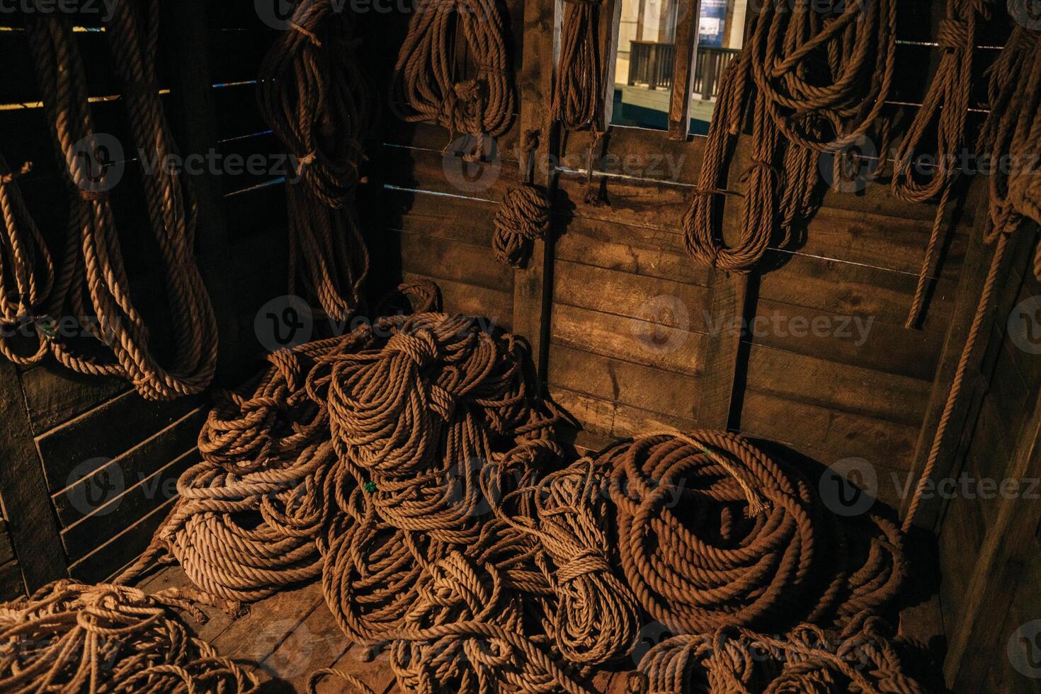 A lot of weathered ropes on the side sailboat. Vintage old Boat with twisted ropes. photo