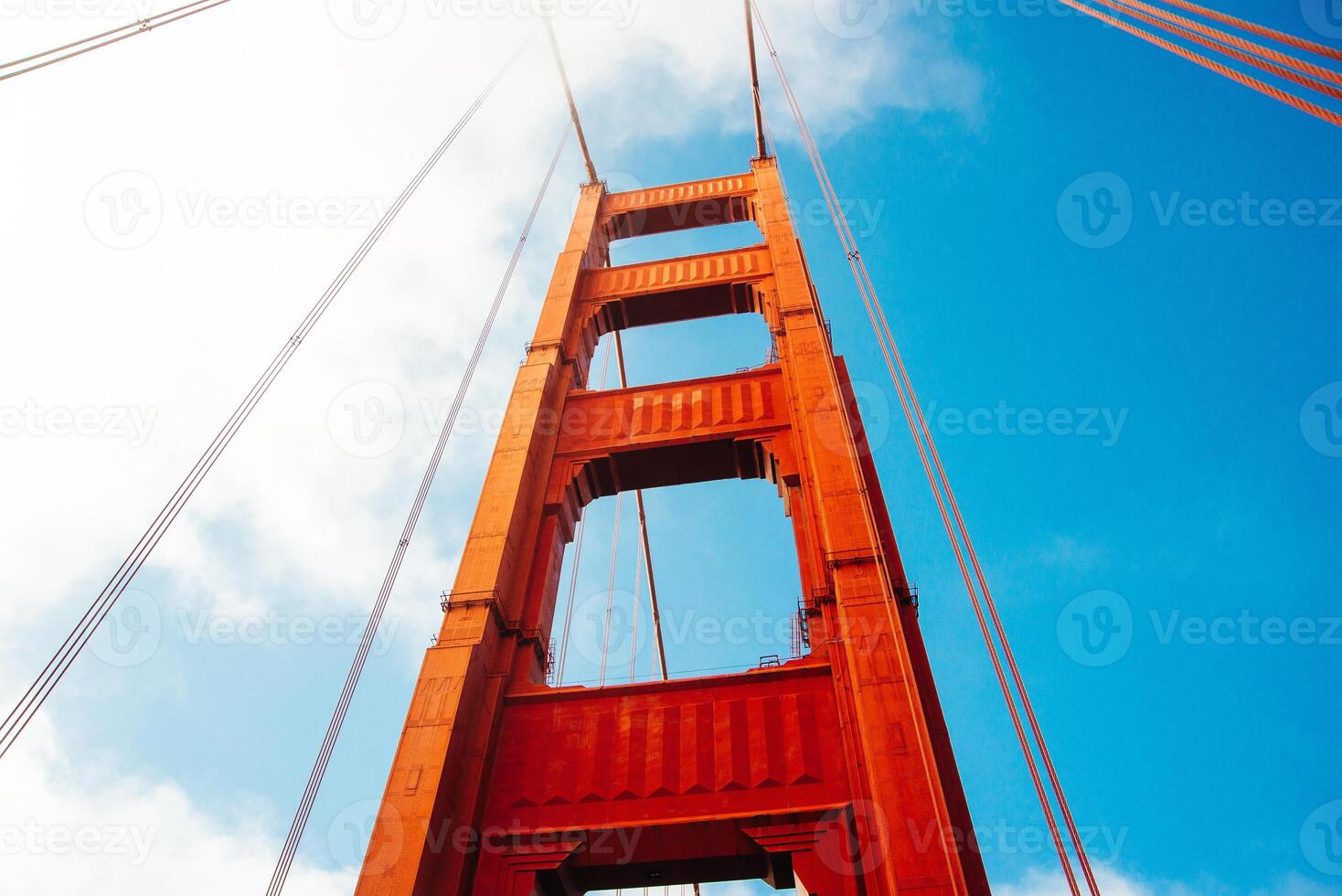 Close up of single tower of Golden Gate Bridge in white clouds San Francisco, USA, bottom view.. photo