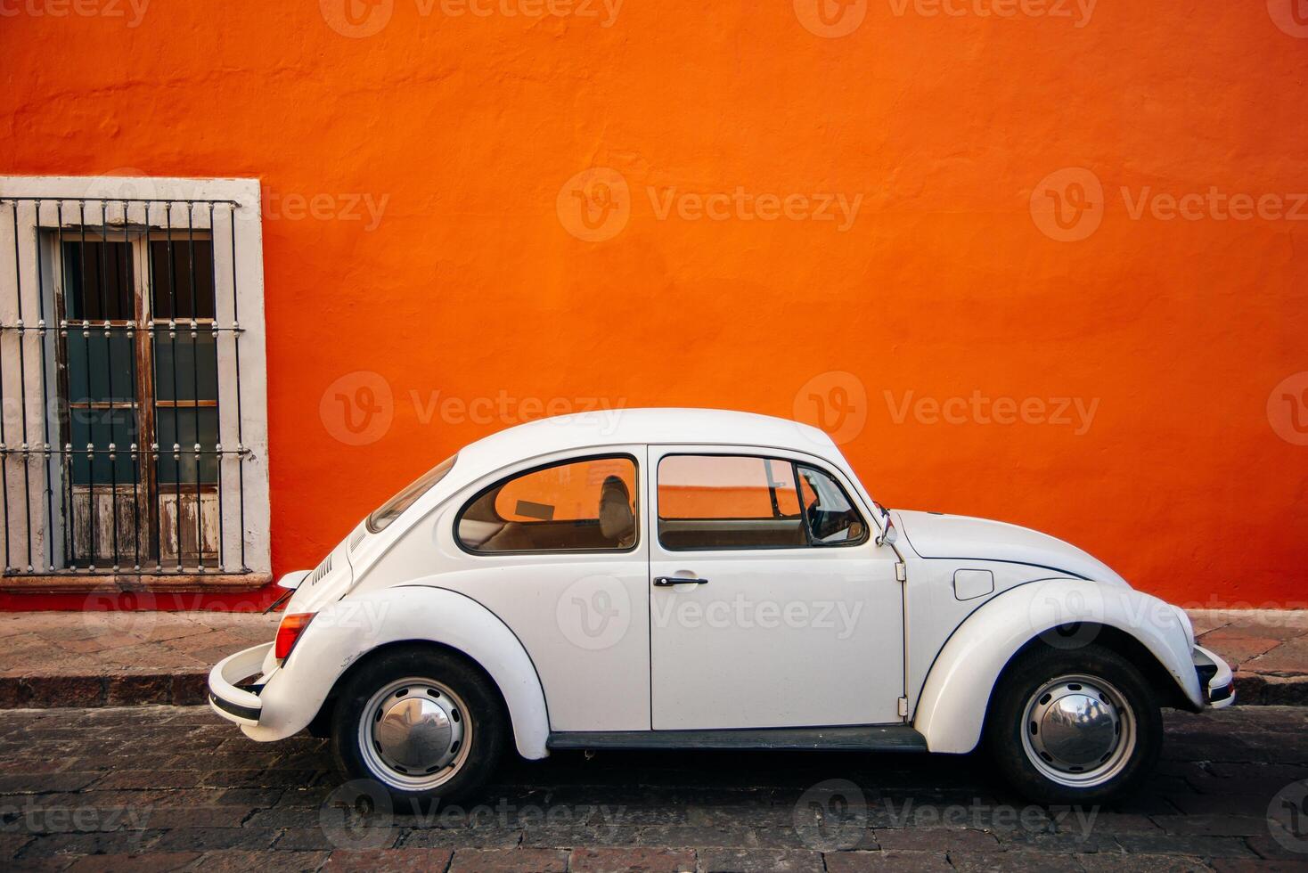 white old Volkswagen near orange wall in mexico - sep, 2019 photo