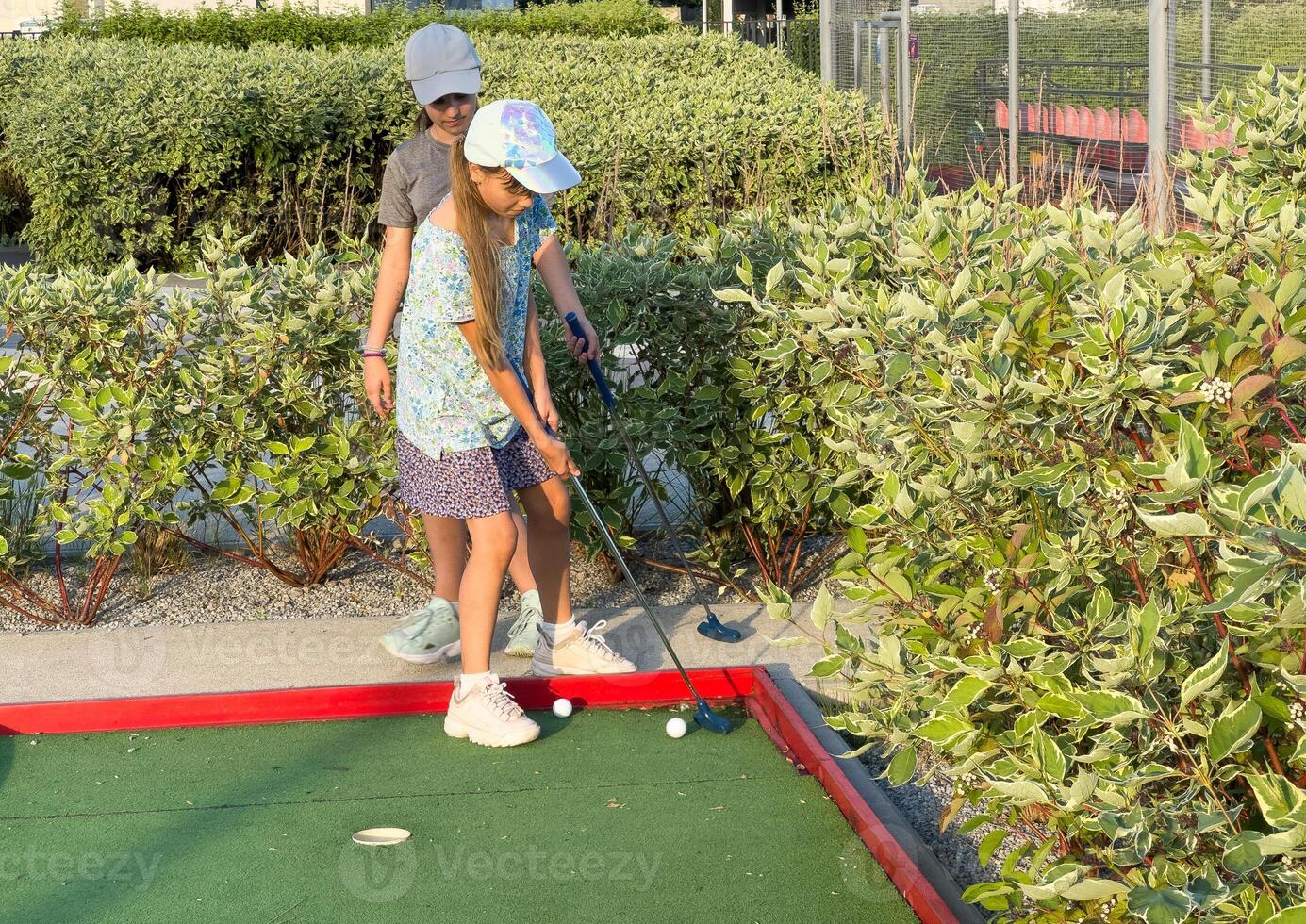 teenage girls play mini golf photo