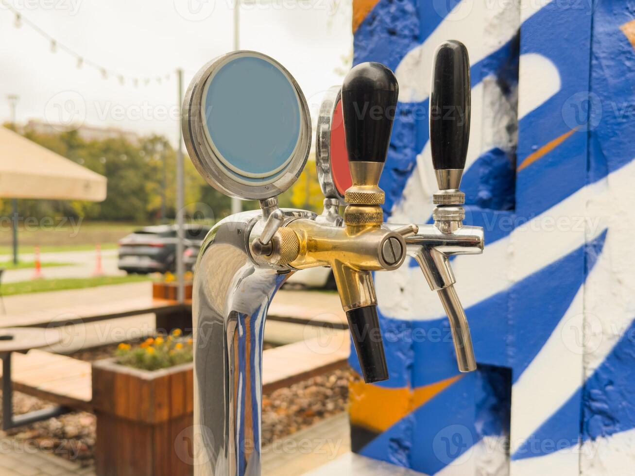 Bar counter with draft beer taps in open-air cafe photo