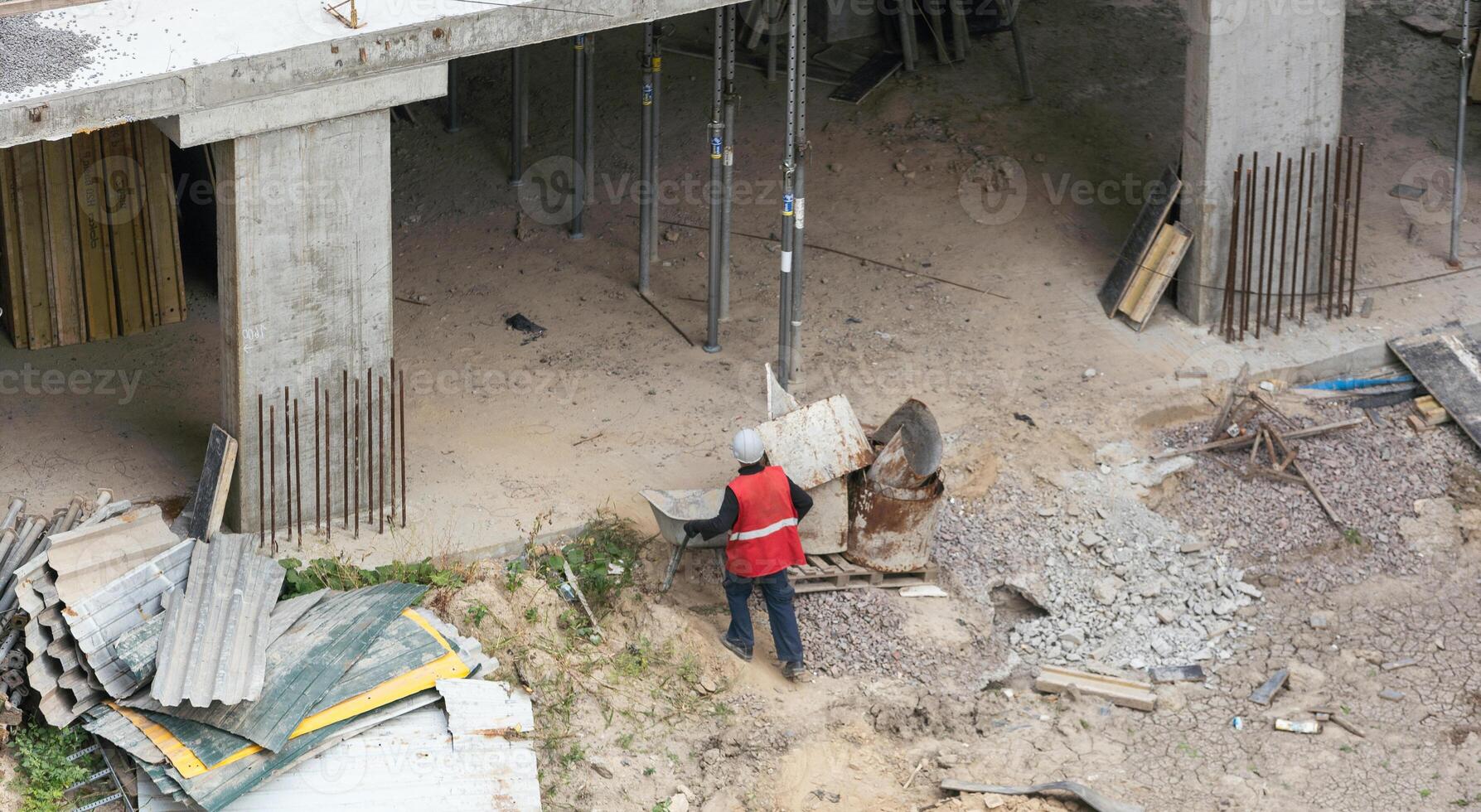 building and construction worker, male in safety hard hat helmet working on steel wire mesh for concrete slab reinforcement at Prefabricated concrete walls Manufacturing photo
