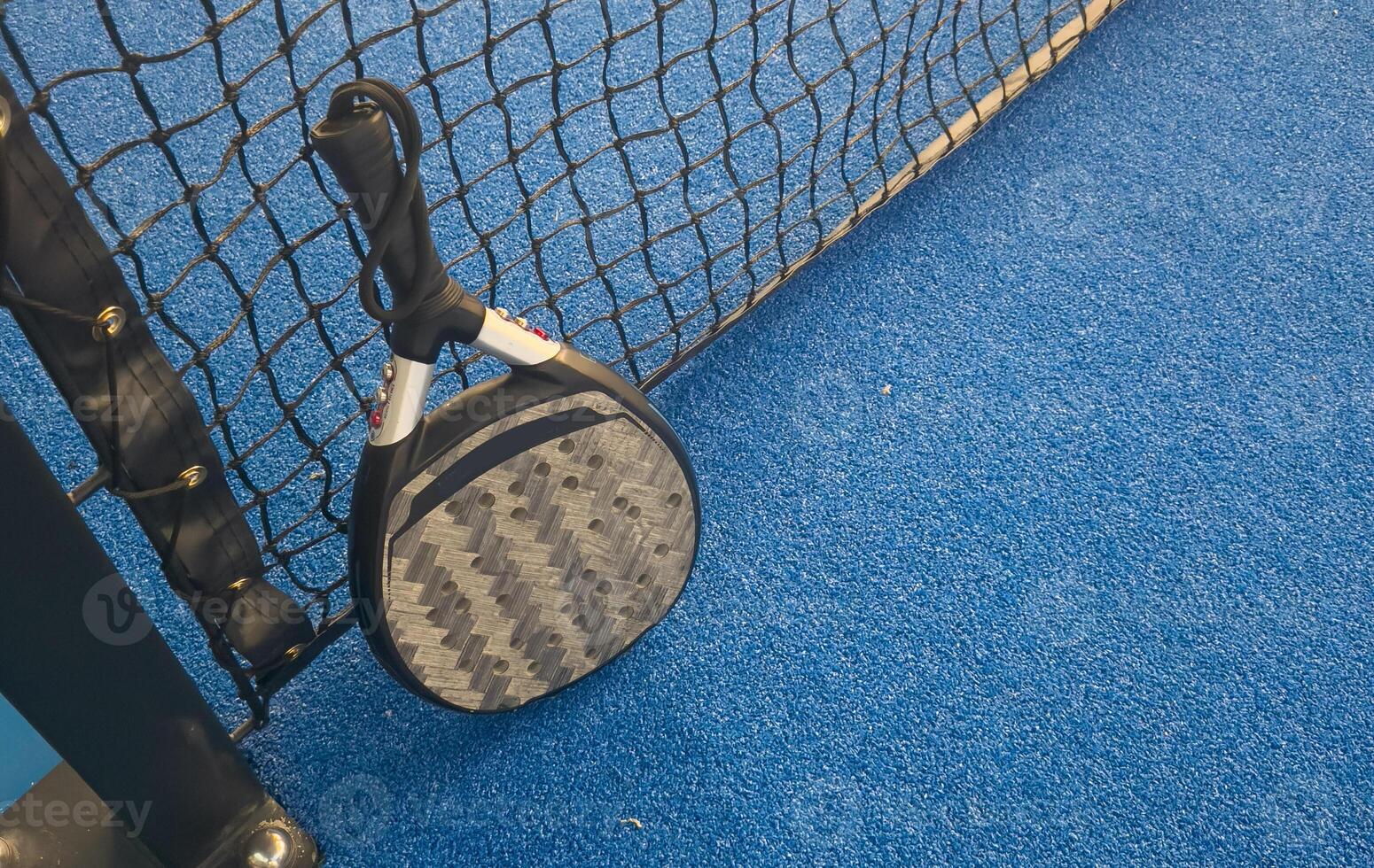 paddle tennis racket and balls on court photo