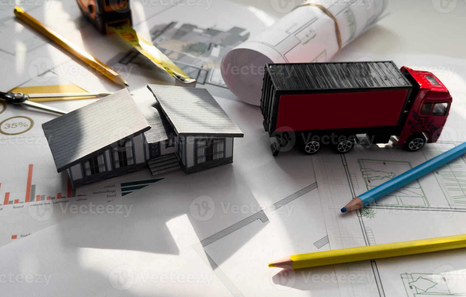 Close up of small replica of a truck on blueprint and engineer hands sketching a construction architectural project. photo