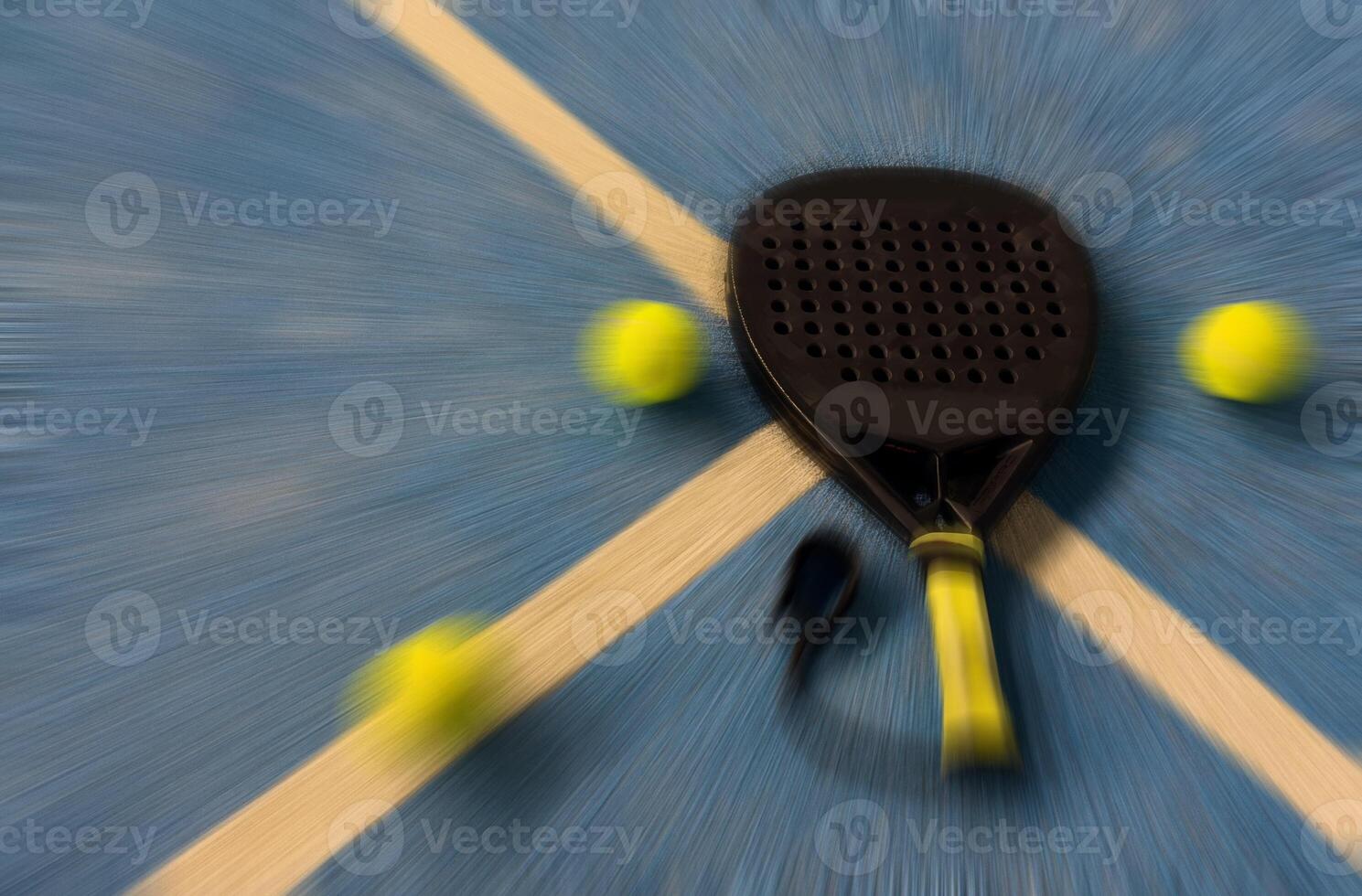 A padel racket lies on the blue court beside a bright yellow tennis ball, just inches from the net, capturing a moment during a game played in an indoor facility. photo