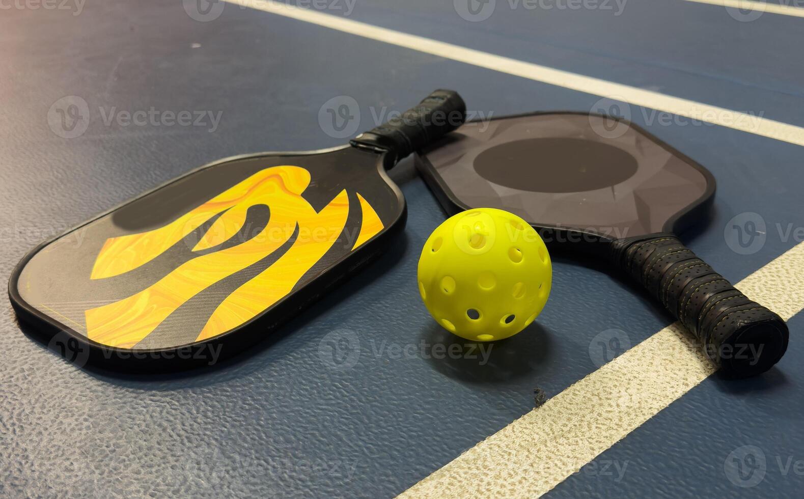 Pickleball tennis racket on the court. Blue background with copy space. Sport court and ball. photo