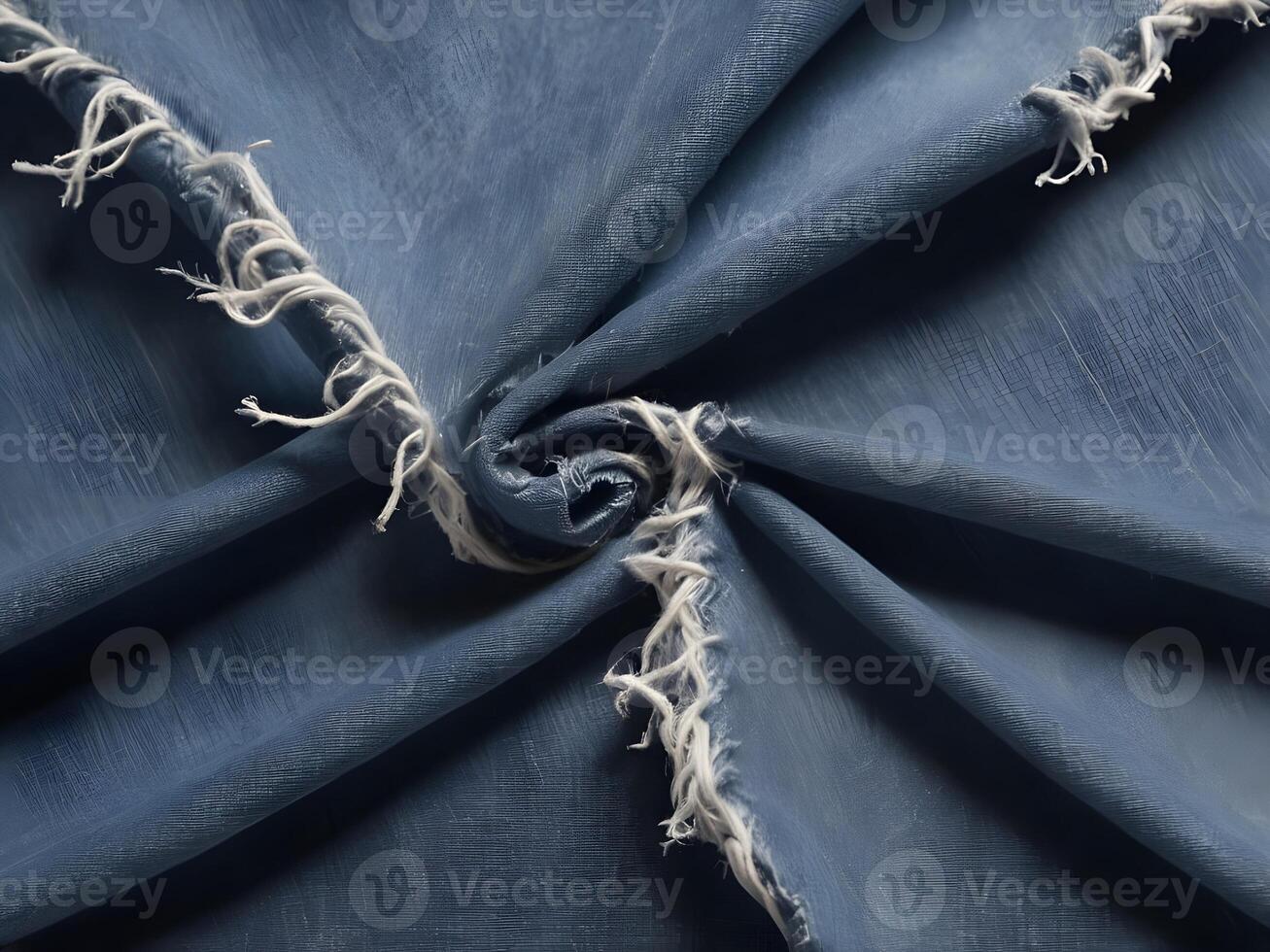 A macro capture of denim with visible fraying and loose, hanging threads. photo