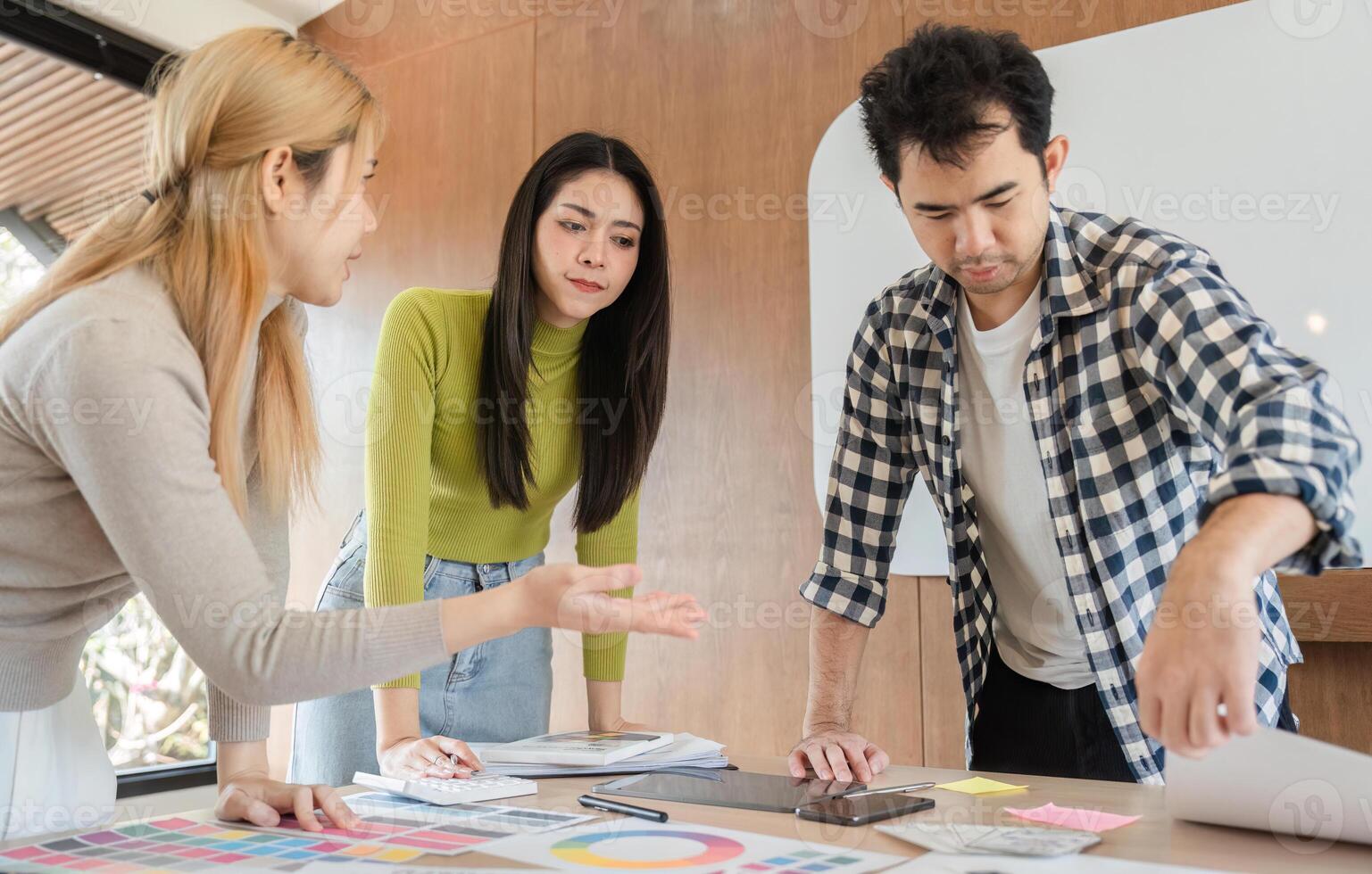 Diverse team collaborating on design project in modern office workspace. photo