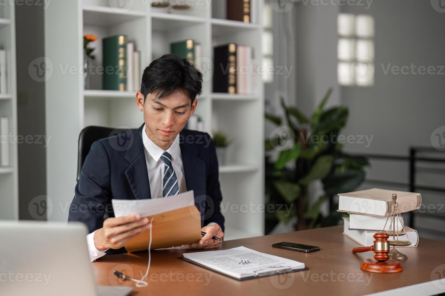 Young businessman reviewing important documents and preparing for tasks in a modern office setting. photo