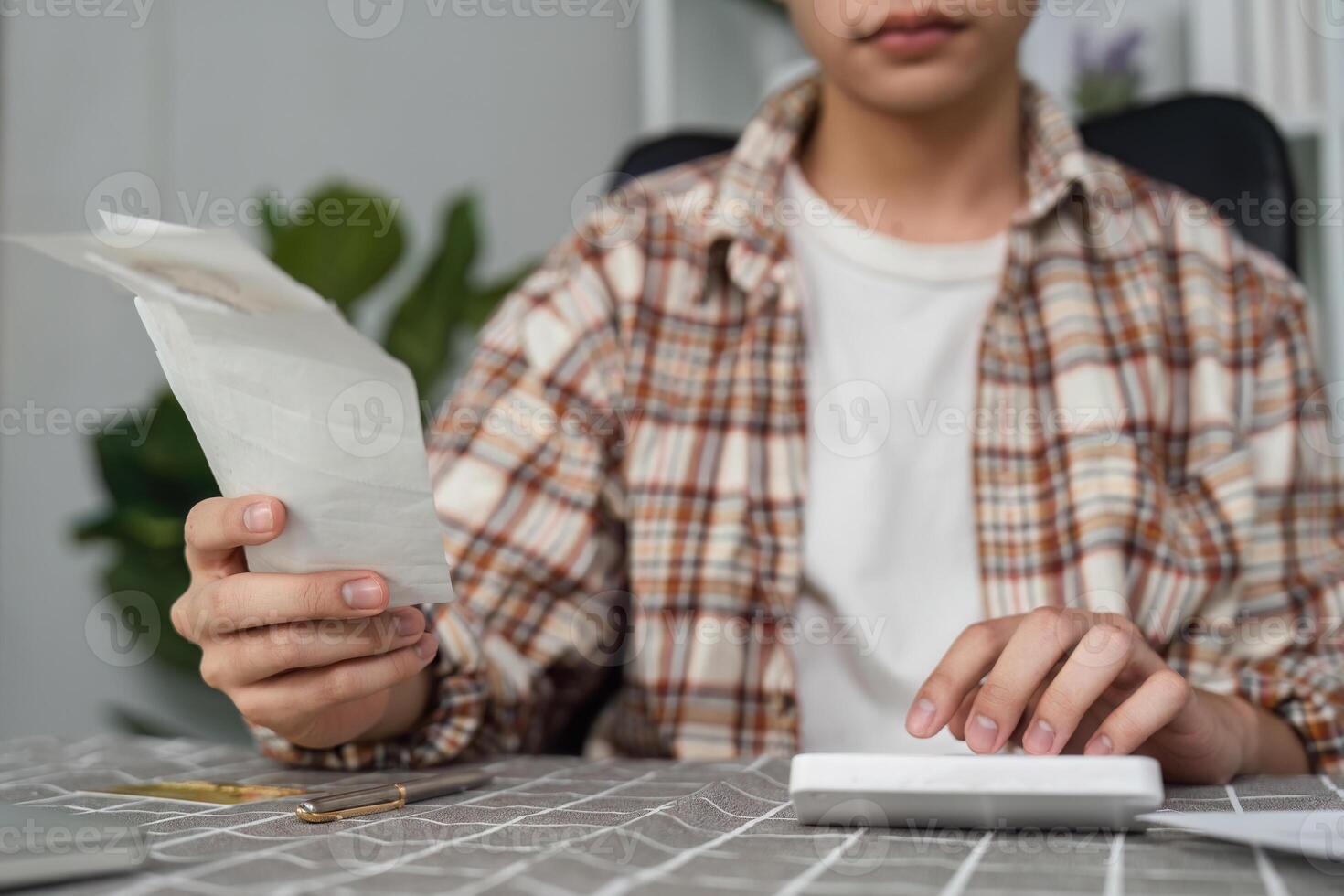 Focused young professional calculating finances with documents in a chic office setting photo