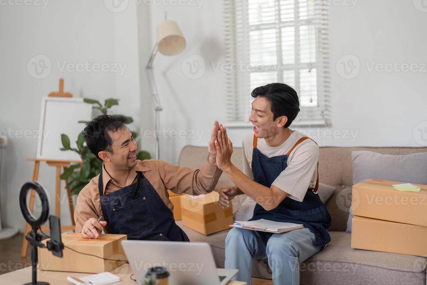 Two online sellers engaged in a fun brainstorming session in their stylish home workspace. photo