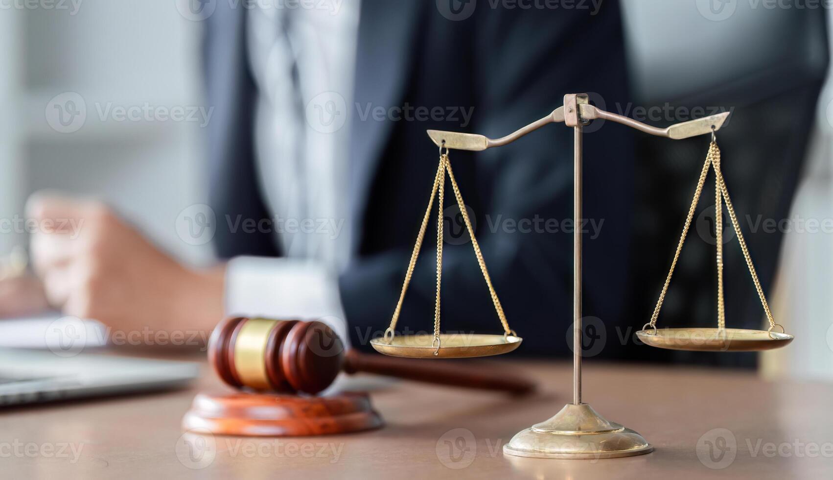 Lawyer analyzing legal documents with scales of justice and gavel on desk in modern office setting. photo