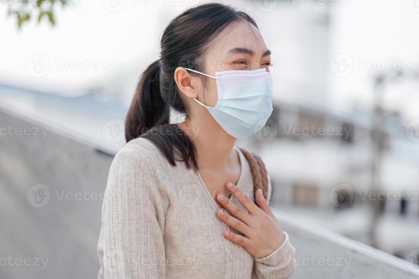 Cheerful woman in a mask smiling while using her smartphone, promoting health and safety in polluted areas. photo