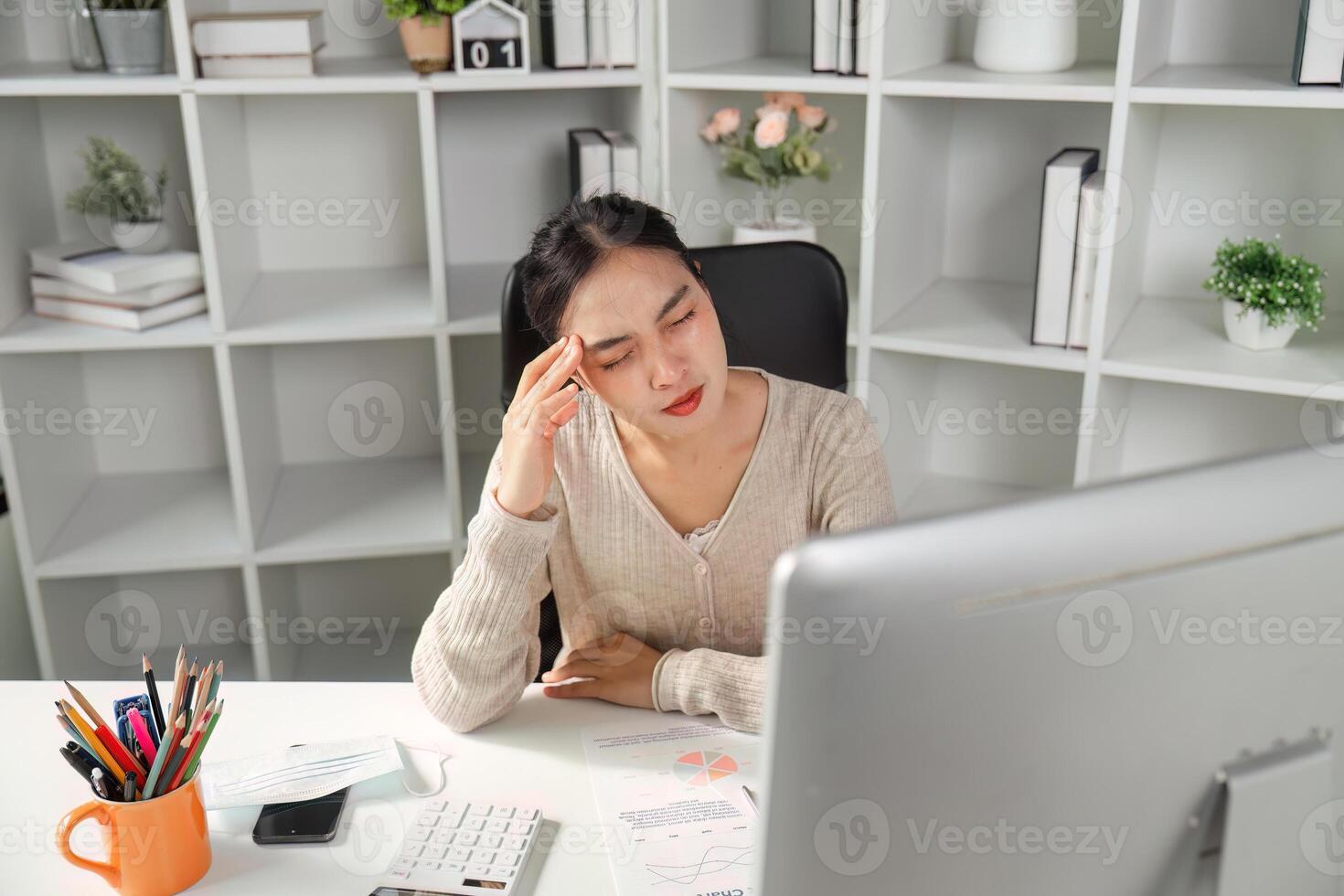Stressed office worker dealing with financial data and reports in a modern workspace. photo