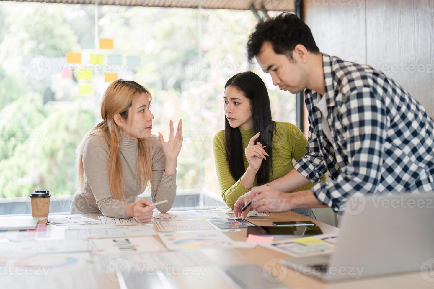 Diverse team members engaged in a design discussion and collaboration in an office. photo