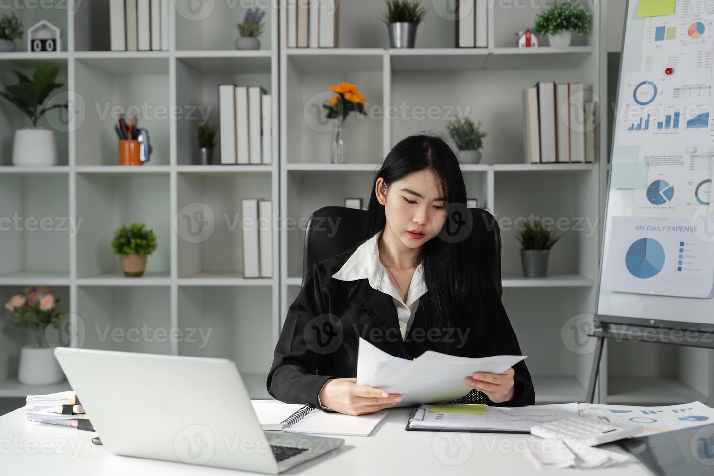 Accountant reviewing financial reports and documents in a modern office setting, focusing on tax preparation. photo