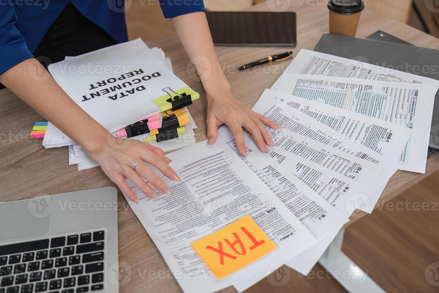 Accountant organizing tax documents and financial reports on a desk photo