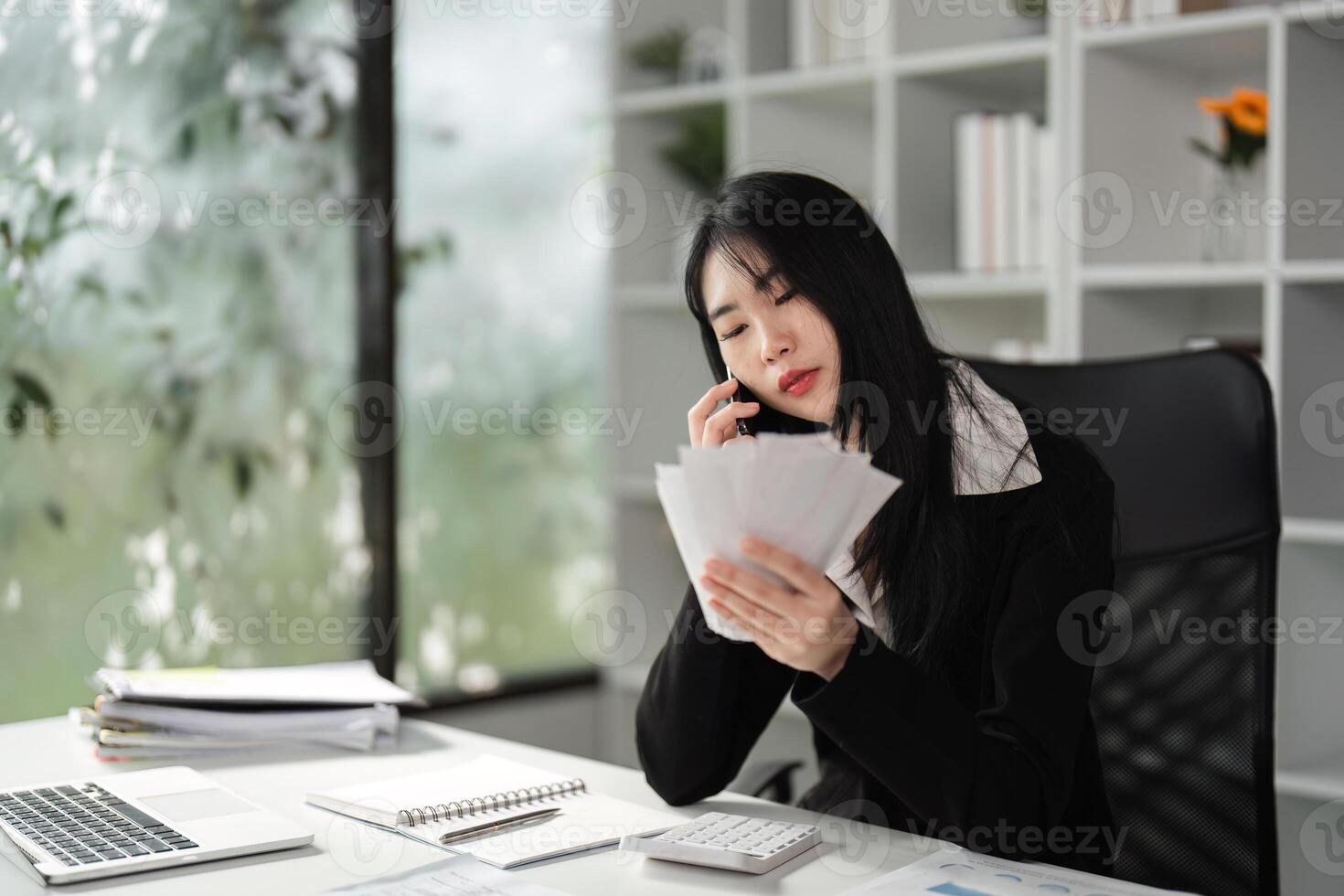 Accountant on the phone while reviewing financial documents. photo